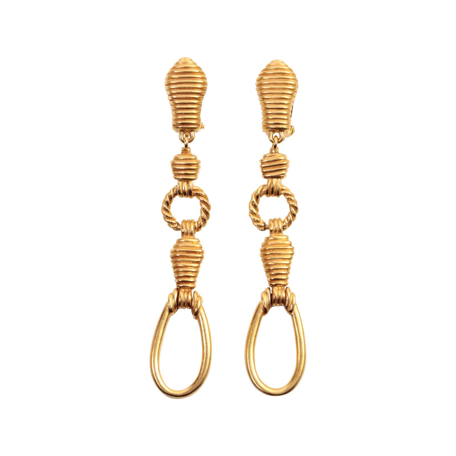 Vintage Christian Dior Boutique Gold Long Drop Earrings, circa 1980s. These earrings feature various textured elements in different sizes that hang down.  They are unique because they are long but not wide, making them a chic choice.  They were