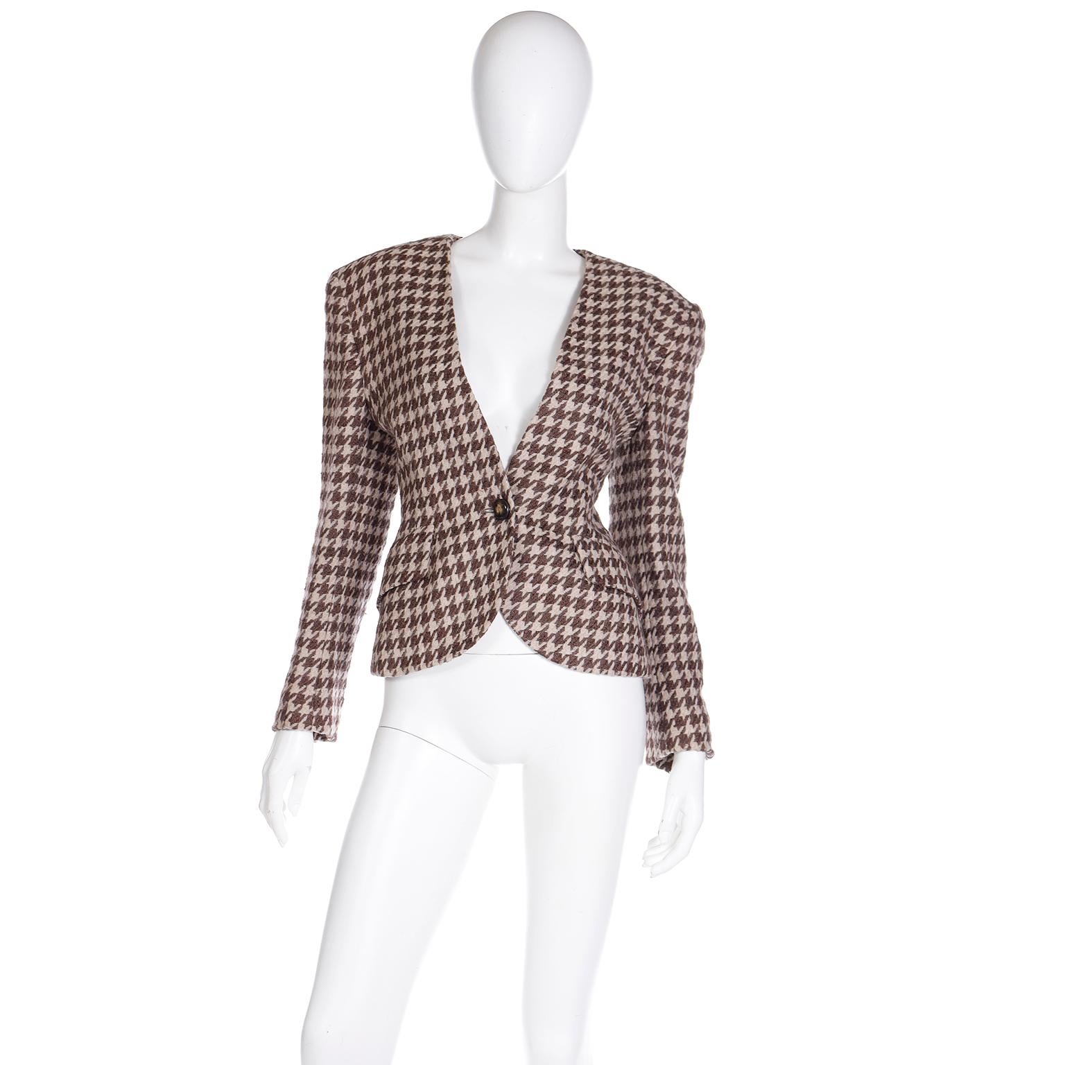 This fun vintage 1980's Christian Dior brown and ivory houndstooth check jacket has a flattering silhouette with a fitted waist and slightly cropped length. This wool jacket is fully lined and has a glossy wood grain button for closure at the waist.