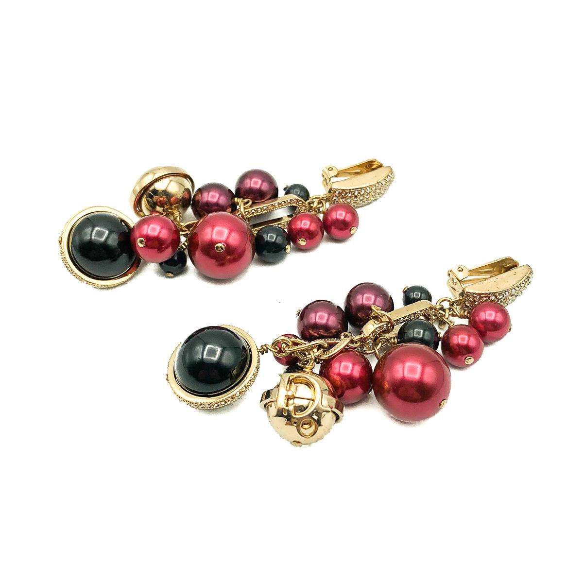 A pair of Vintage 2000s Dior Sphere Earrings. Featuring a sublime array of deep pink, black and gold spheres suspended from crystal encrusted links. The gold spheres carrying the iconic name of Dior. Crafted from gold plated metal, crystal, glass