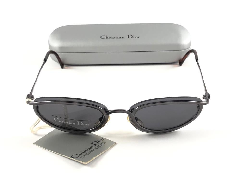 Vintage Christian Dior Sunglasses 1990's metallic silver frame. medium smoke grey lenses.

Made in Austria.
 
This piece show minor sign of wear due to  storage.

Front : 12.5 cms

Lens Height : 3.5 cms

Lens Width : 5.6 cms 