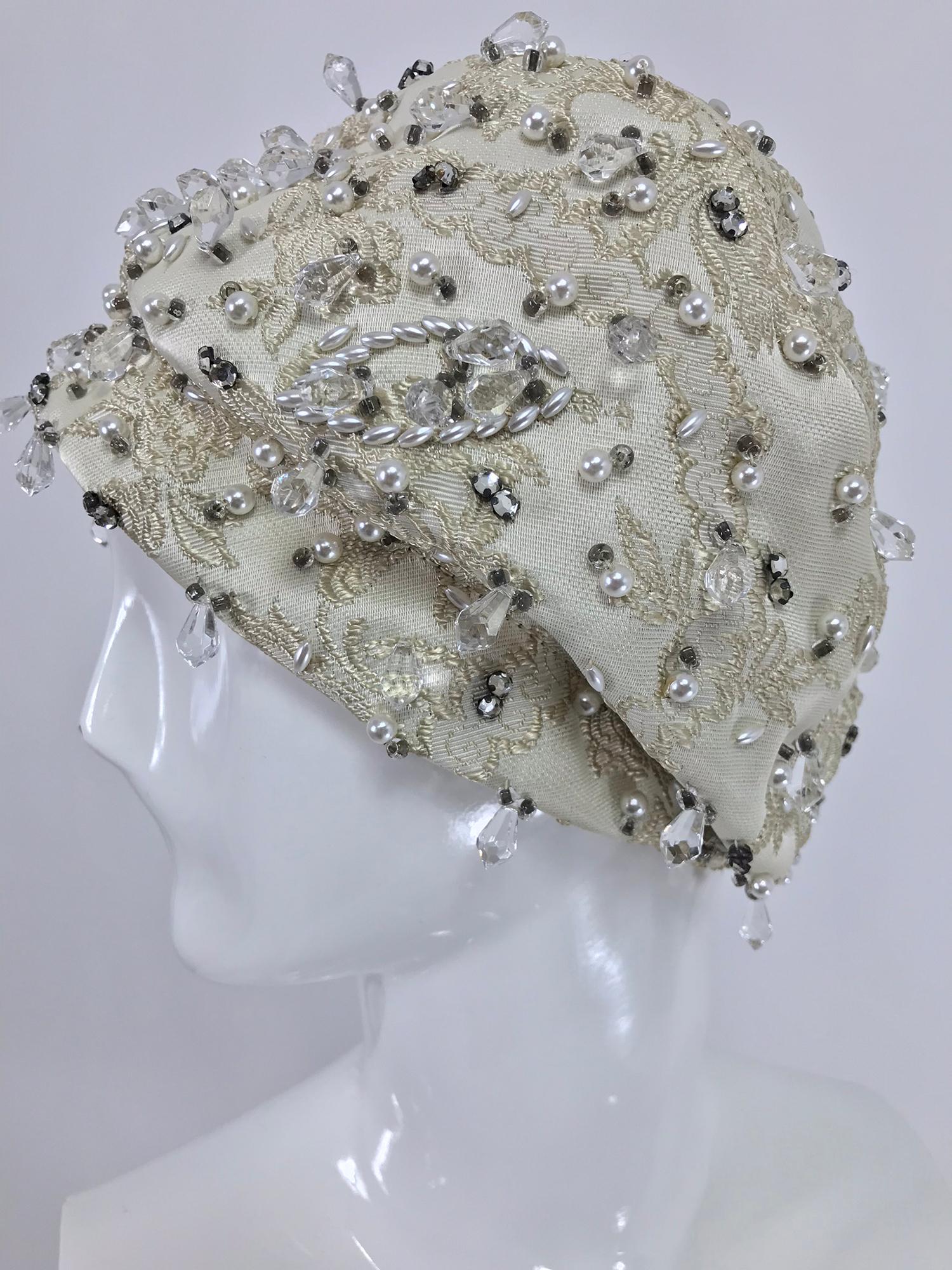 Vintage Christian Dior cream brocade beaded turban hat from the 1960s. Marked size 22.

Measurements are in inches:

21 1/2 inside at band

5 1/2 high