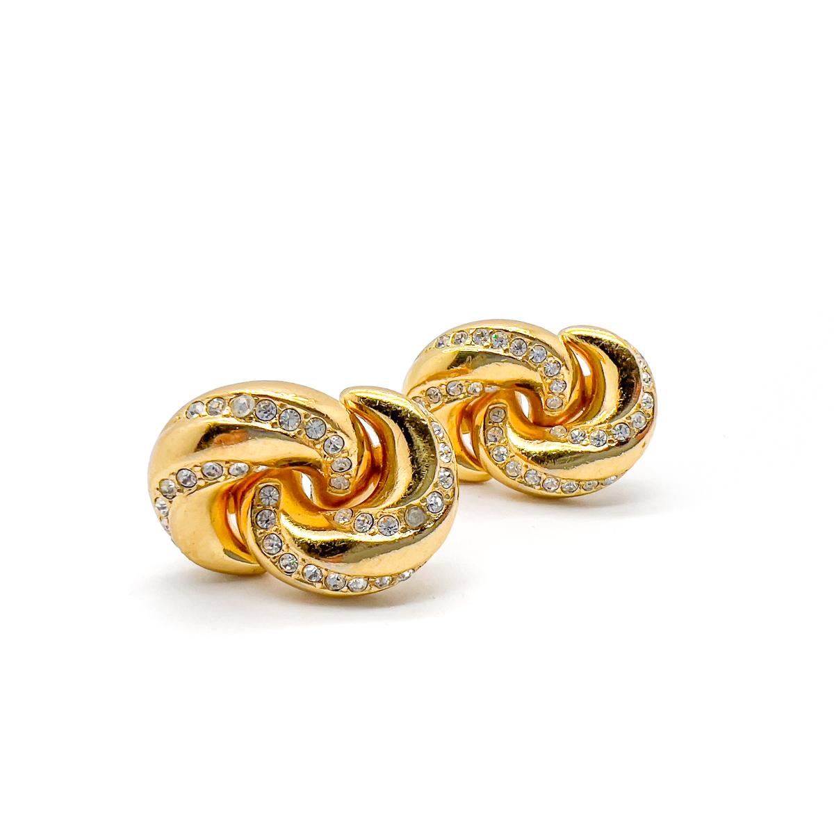 Ein Paar Vintage Christian Dior verschönert Love Knot Ohrringe. Mit verschlungenen goldenen Loops, die einen Liebesknoten darstellen. Die hochglanzpolierten und mit Steinen besetzten Oberflächen sorgen für einen perfekten Kontrast und ziehen die