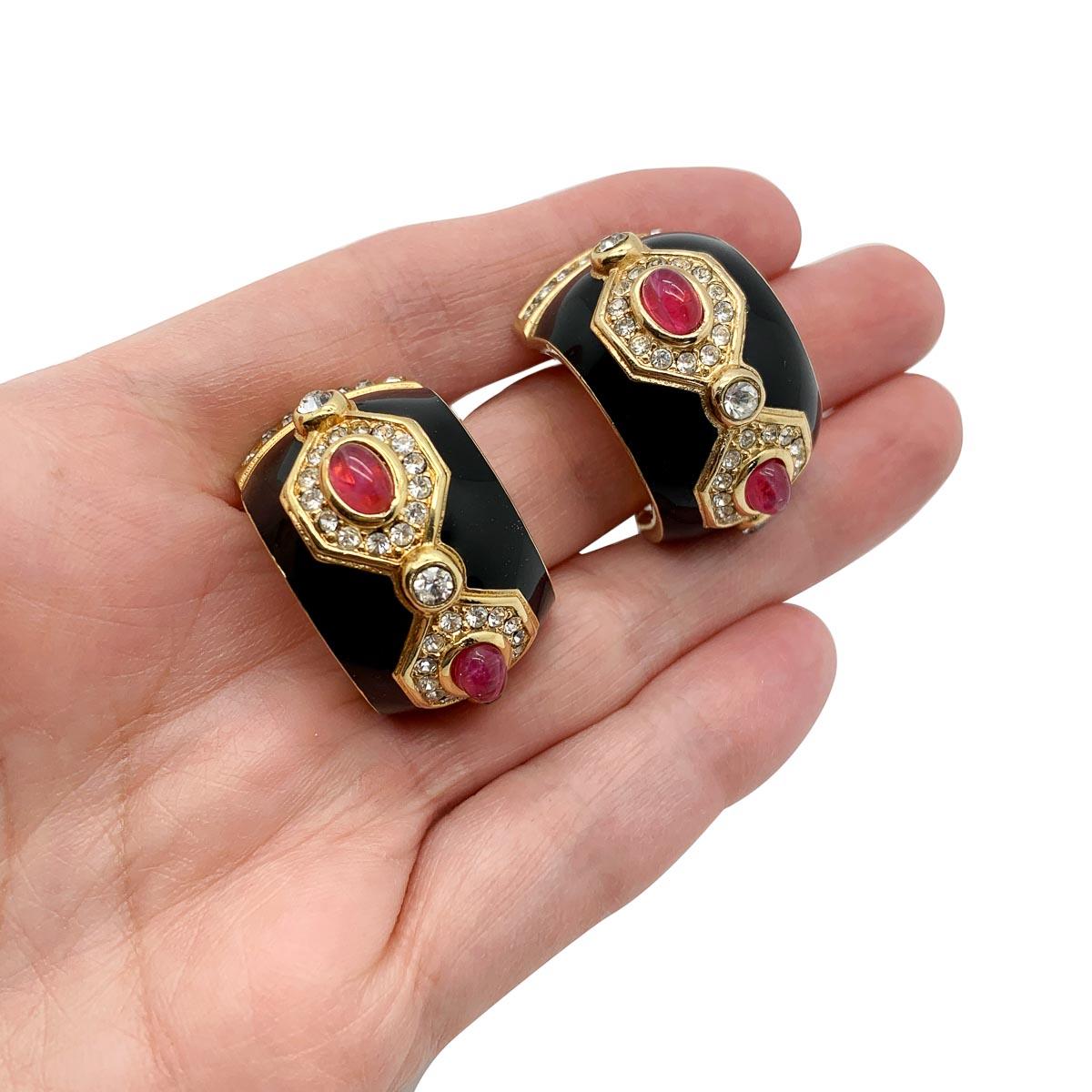 A fabulously luxurious pair of vintage Dior ruby cabochon earrings. Featuring a huggie design with lustrous black enamel finished with stones. The stones, cabochon ruby glass and white chatons, arranged in an art deco style emulating fine jewels to