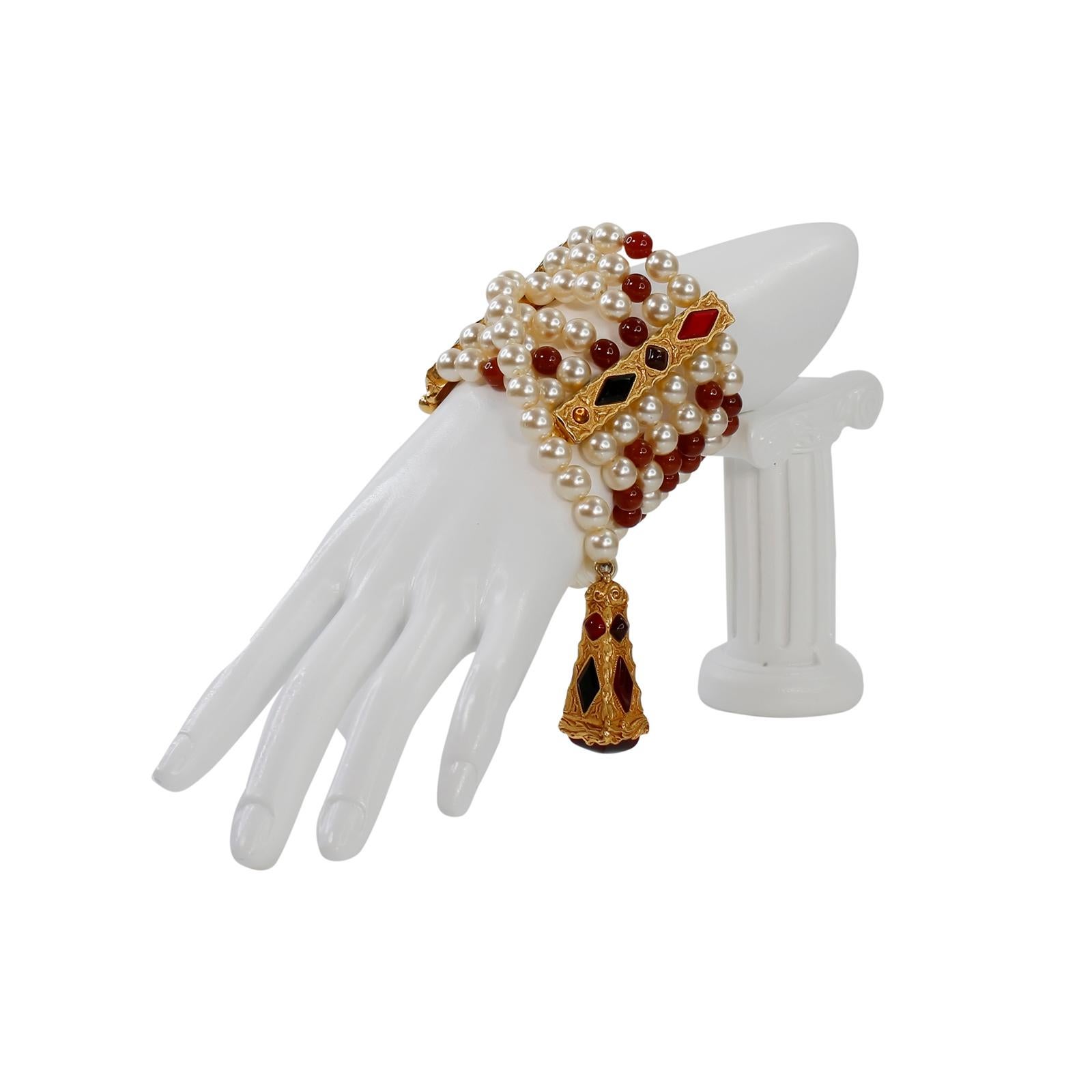 Vintage Christian Dior Gold und  Kunstperlen-Baumelarmband CIRCA 1980er Jahre. Verschiedene rote Perlen und unterschiedliche Schattierungen von rotem Gripoix an diesem 6-strängigen Armband mit einem langen, herabhängenden Strang, der zur Seite