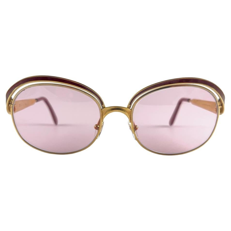 Vintage-Sonnenbrille von Christian Dior. Ockerfarbene Emaille-Details über einem Goldrahmen.
Blassrosa Gläser.
Dieser Artikel weist leichte Gebrauchsspuren und Anlaufen an der Innenseite der Bügel auf, die beim Tragen nicht auffallen.

Hergestellt
