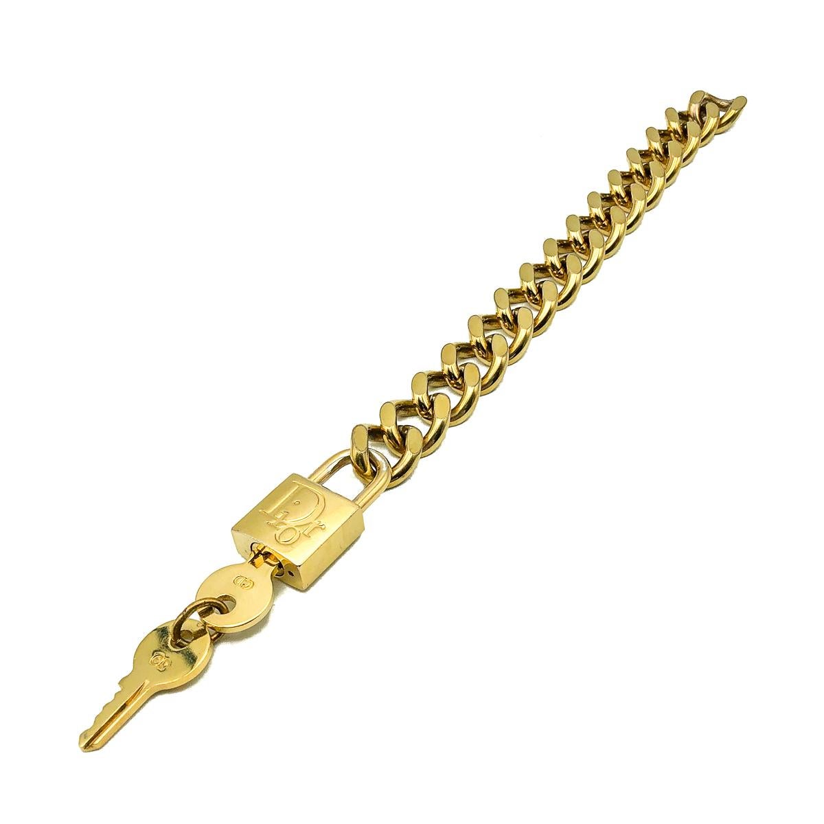 Un bracelet cadenas Dior vintage totalement iconique. Fabriqué en métal plaqué or et doté d'un mécanisme de cadenas qui permet d'attacher et de détacher la chaîne. Très bon état vintage. Chaîne d'environ 18,5 cm. Clés amovibles. Un bracelet vintage