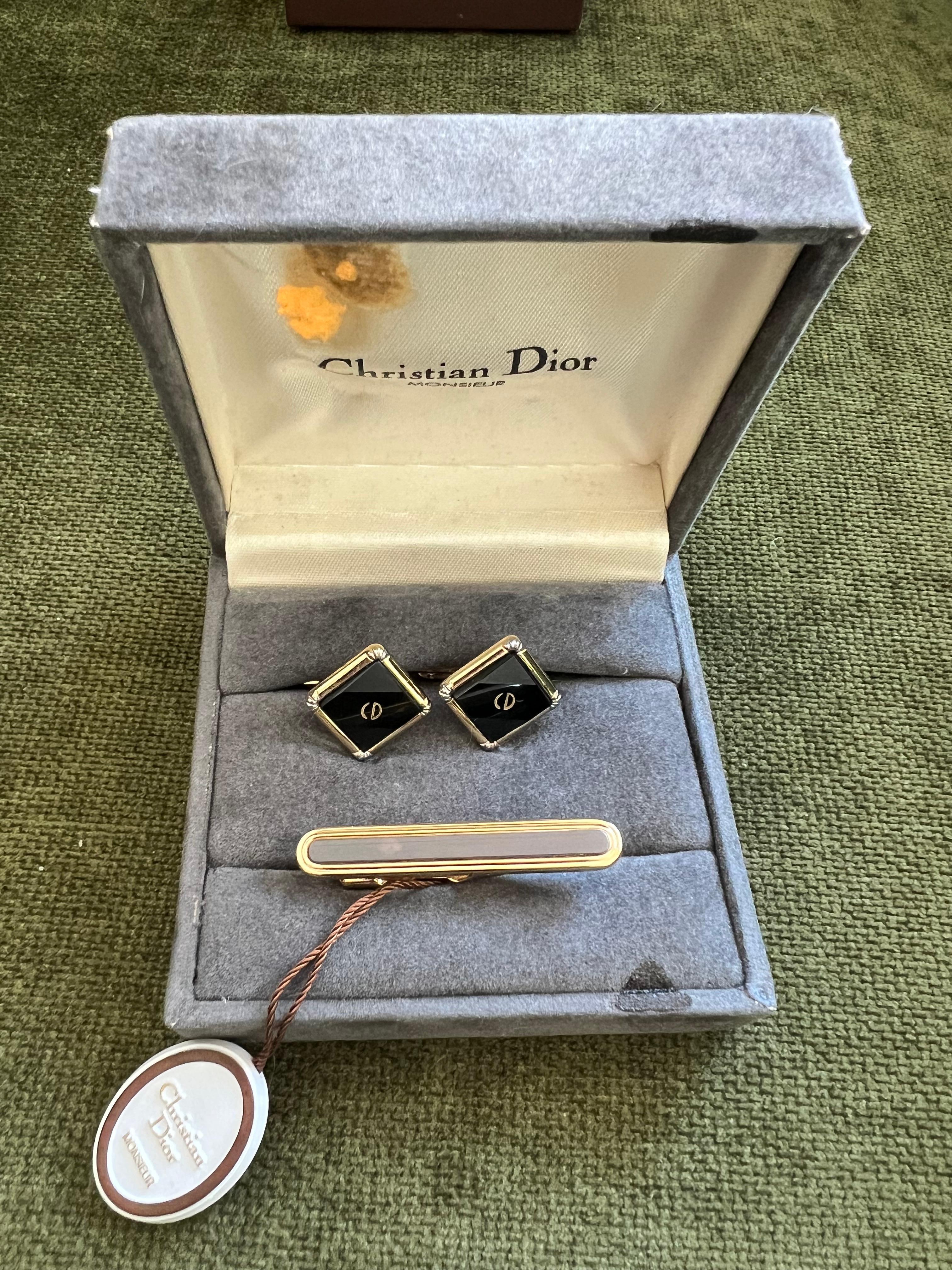 Gemelos y pasador de corbata vintage de chapa de oro y ónice de Christian Dior Circa 1980 En estuche original 
Con logotipo Dior en la parte delantera, fondo texturizado.

