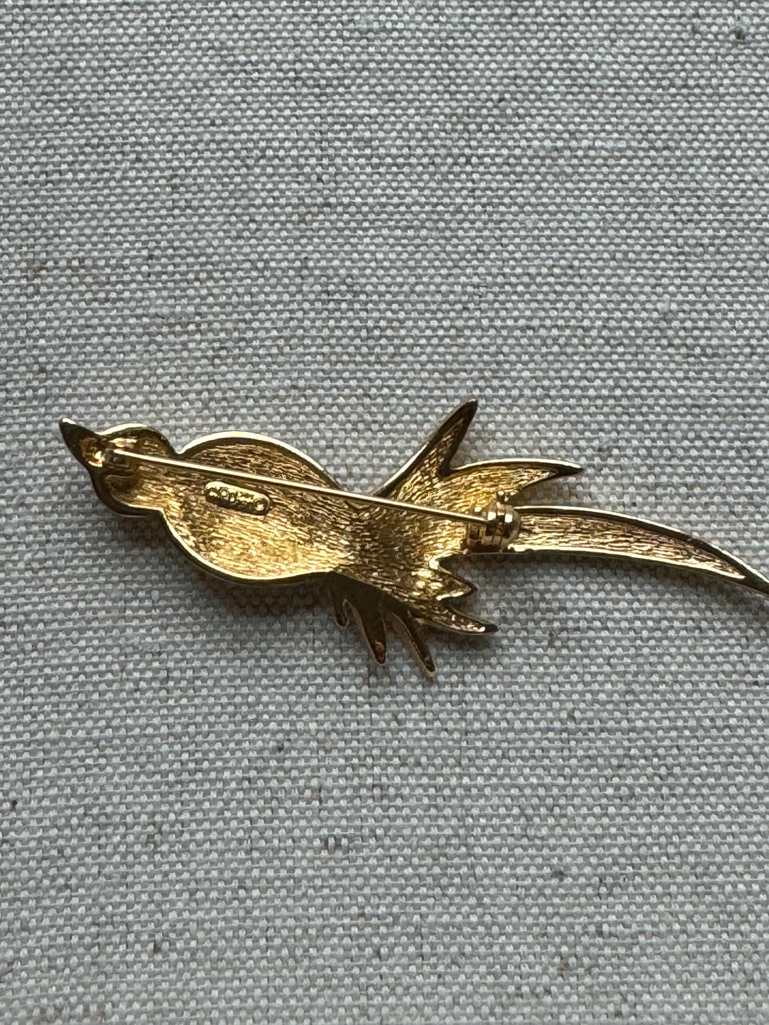 Beautiful vintage gold tone Christian Dior Bird Brooch.
Pin displays excellent condition. The head consists of 7 round crystals and the body of the bird consists of 25 crystals. The birds texture displays a combination of smooth and textured
