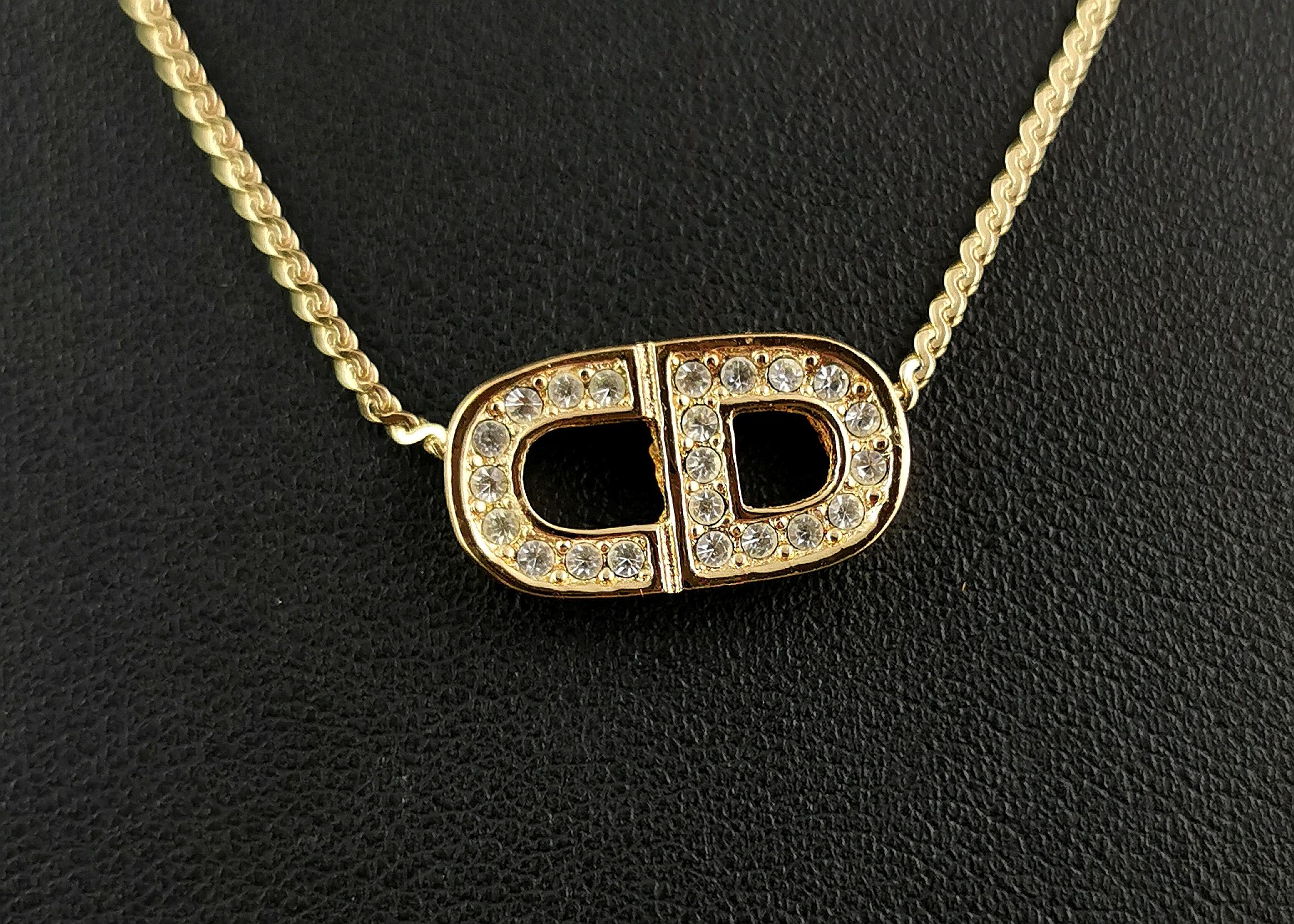 A gorgeous vintage Christian Dior logo pendant necklace.

Gold tone metal, the pendant is made up from a chunky little C and D both studded with clear diamante stones.

The pendant comes on the original Dior gold tone chain and this has a spring
