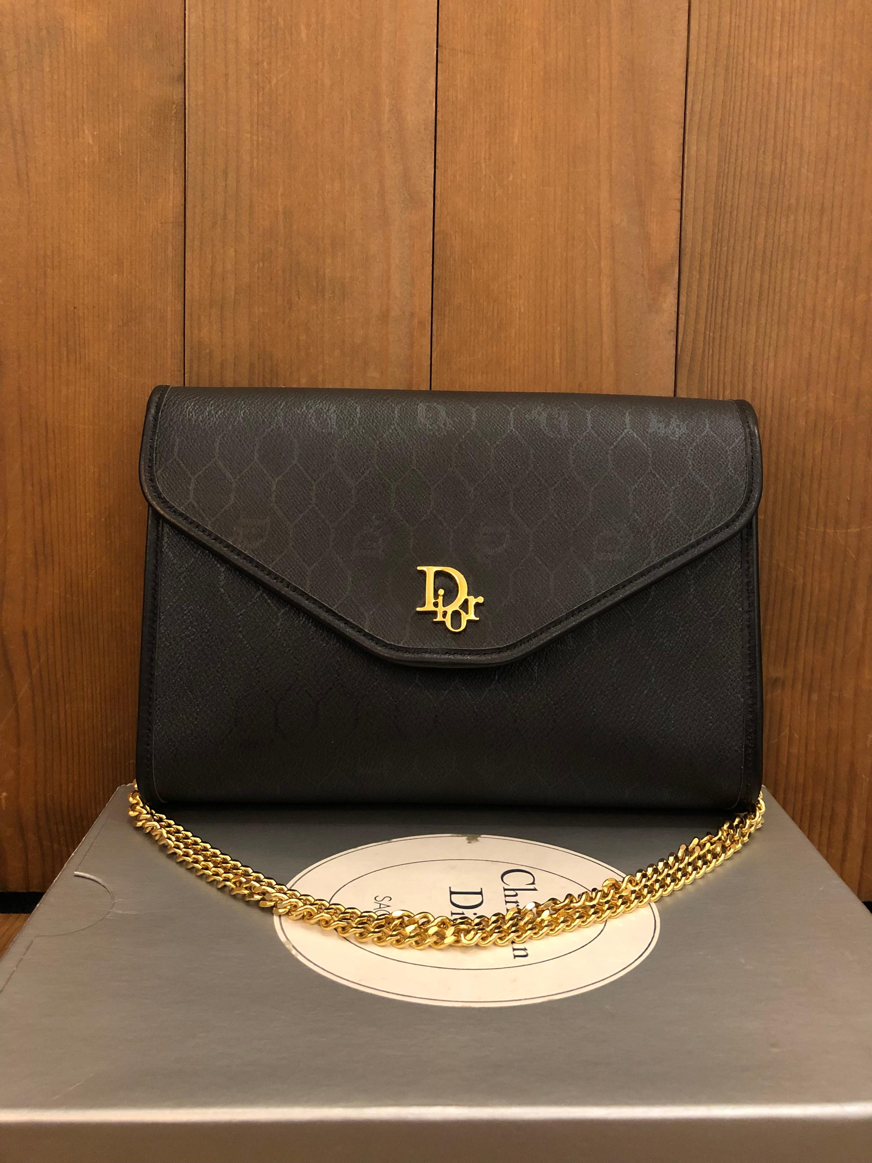 This vintage CHRISTIAN DIOR chain shoulder bag is crafted of Dior honeycomb coated canvas in black and gold toned hardware. Front flap snap closure opens to a coated interior which has been professionally cleaned. Made in France. Measures