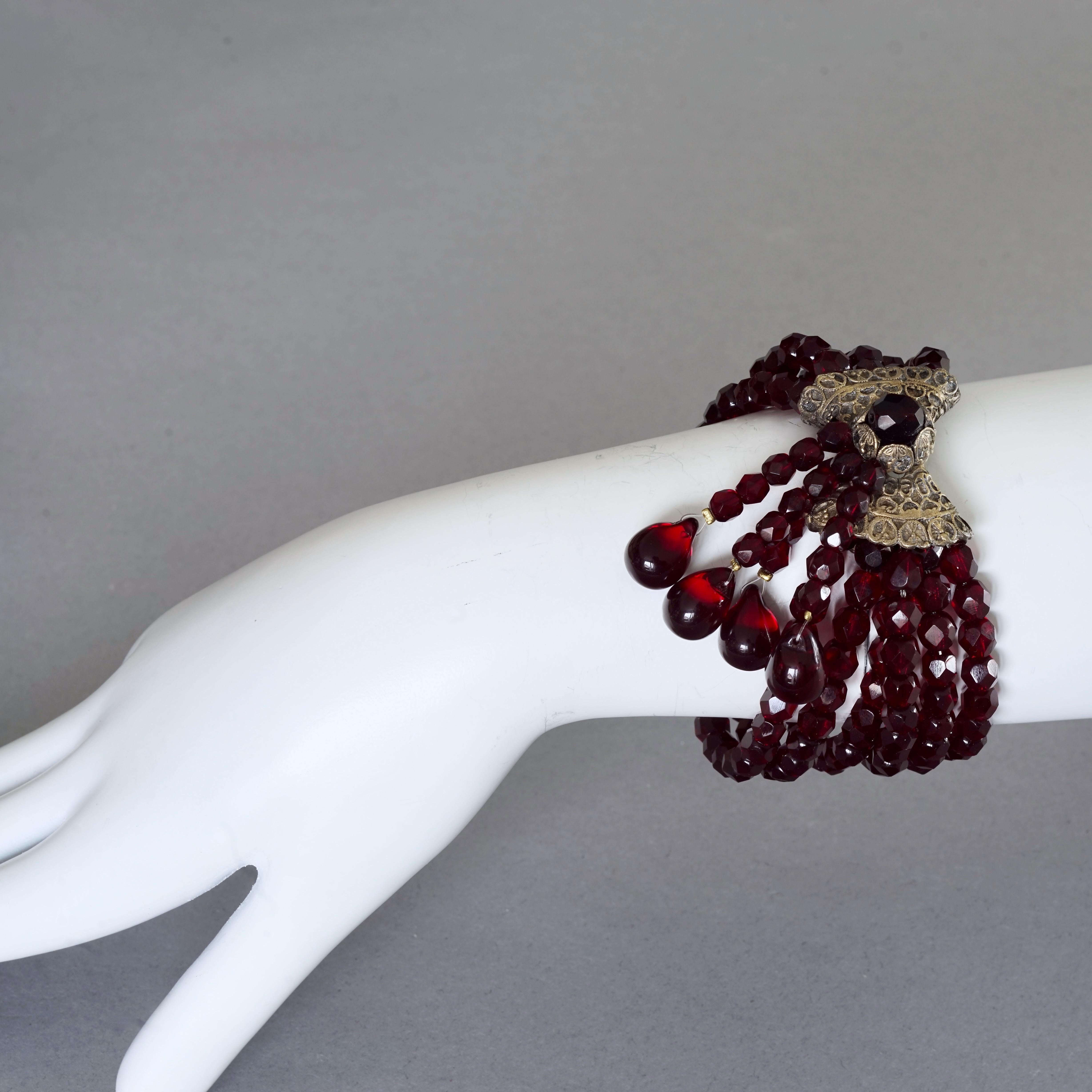 Vintage CHRISTIAN DIOR Hypnotic Poison Multi Strand Garnet Beaded Bracelet

Measurements:
Height: 1.38 inches (3.5 cm)
Wearable Length: 6.69 inches  to 8.66 inches (17 cm)

Features:
- 100% Authentic CHRISTIAN DIOR promotional Hypnotic Poison.
-