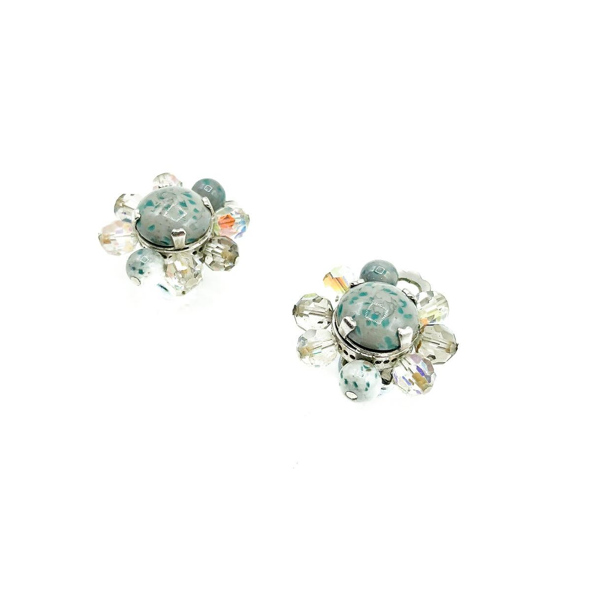 A beautiful and very feminine pair of Vintage Dior Ice Blue Clips from 1958. Crafted with speckled glass cabochon stones in a most fabulous blue grey tone, with aurora borealis crystals set individually with claws and pins. In silver tone metal. In