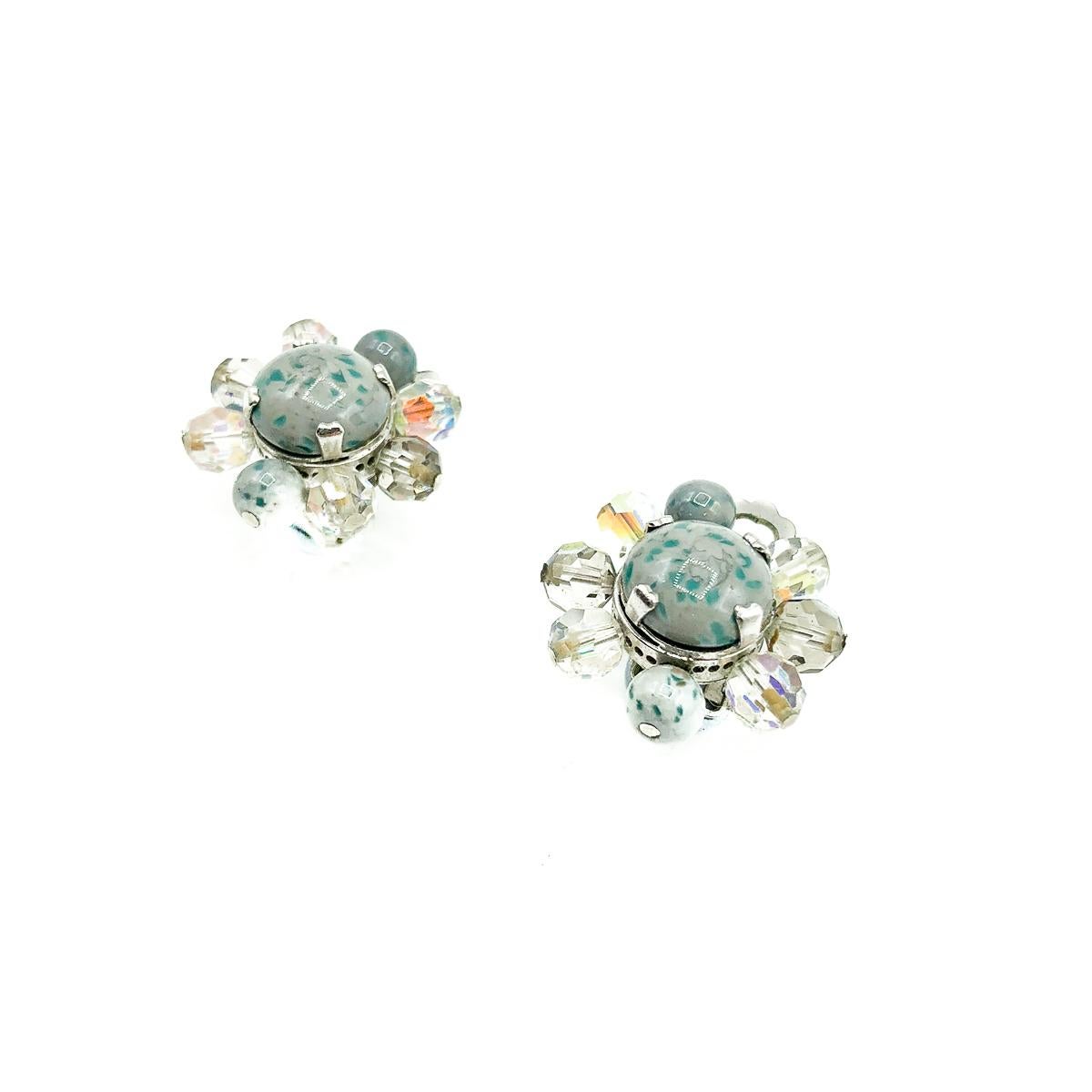 Un hermoso y muy femenino par de Clips Vintage Dior Azul Hielo de 1958. Elaborada con piedras cabujón de cristal moteado en un fabuloso tono gris azulado, con cristales de aurora boreal engastados individualmente con garras y alfileres. En metal de