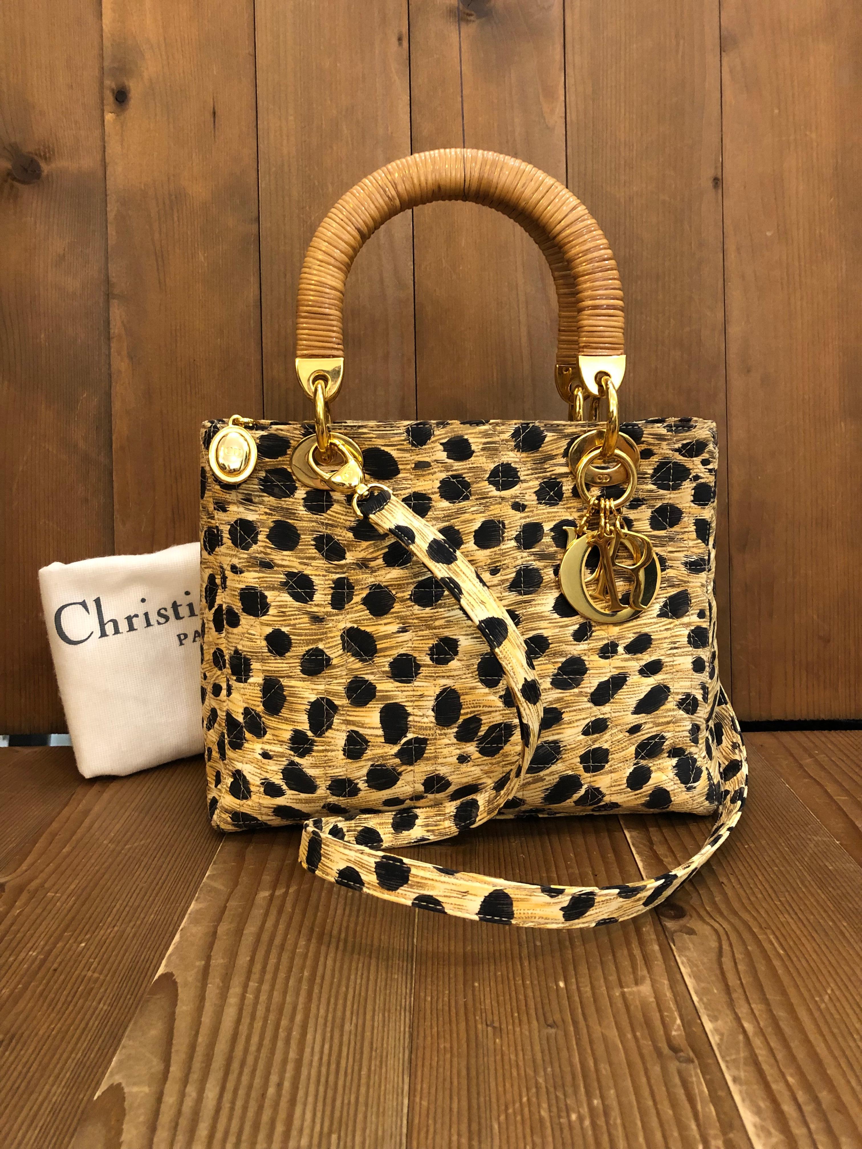 This vintage Lady Dior is crafted of black and yellow leopard printed nylon in Dior signature cannage pattern with gold toned hardware featuring rattan handles. It can be carried as a handbag or shoulder bag with the detachable shoulder strap that