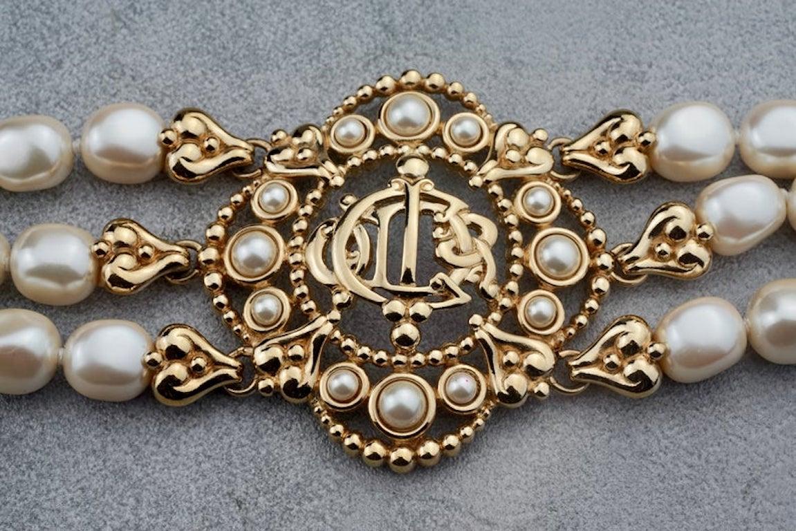 Vintage CHRISTIAN DIOR Logo Insignia Medallion Tiered Pearl Choker Necklace

MEASUREMENTS:
Height: 2.16 inches (5.5 cm)
Wearable Length: 13.78 inches to 15.35 inches (35 cm to 39 cm)

FEATURES:
- 100% Authentic CHRISTIAN DIOR.
- Dior insignia/ logo