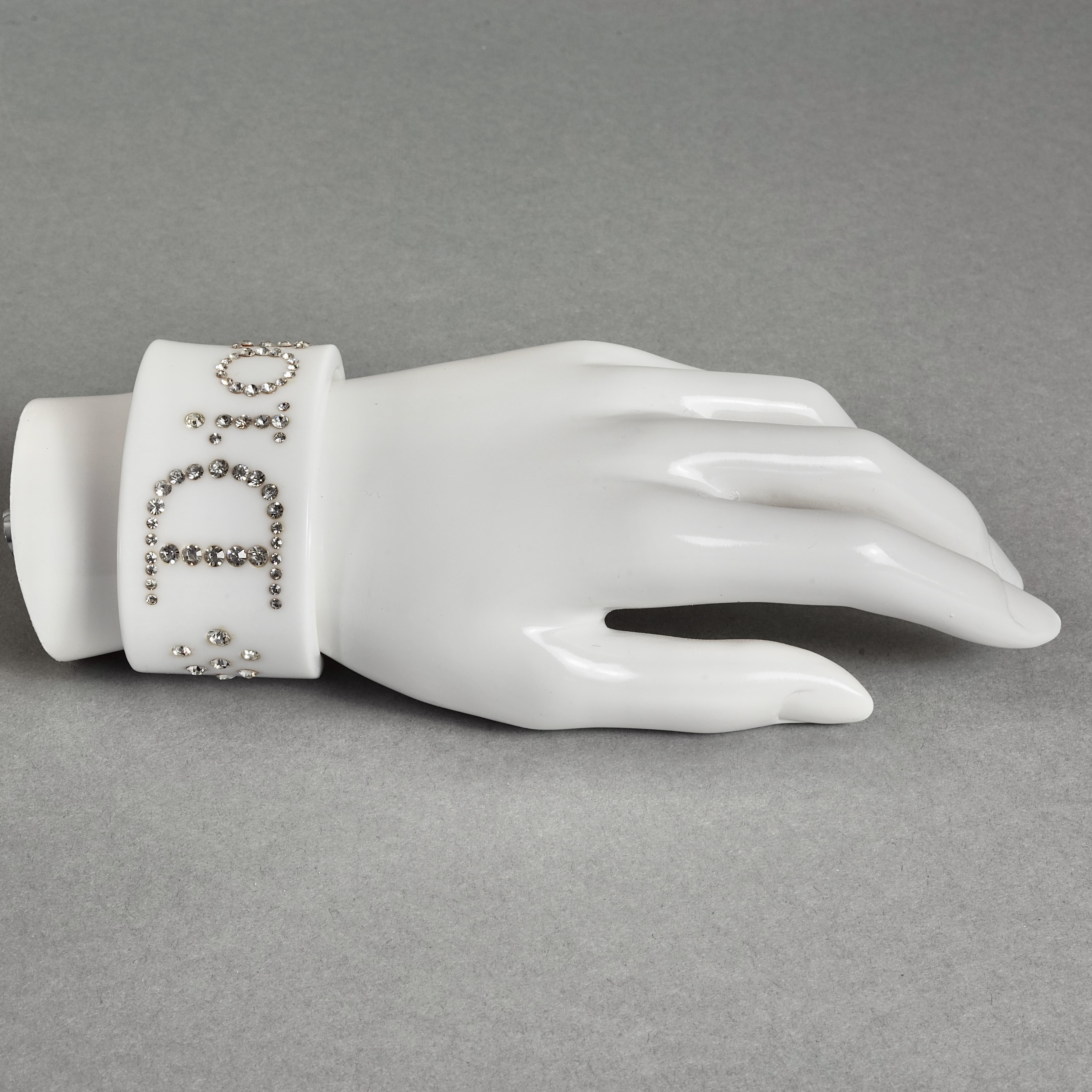 Vintage CHRISTIAN DIOR Logo Rhinestone White Bracelet Cuff

Measurements:
Height: 1.42 inches (3.6 cm)
Inner Diameter: 6.10 inches (15.5 cm)

Features:
- 100% authentic CHRISTIAN DIOR.
- White resin cuff bracelet.
- Spelled DIOR embellished with