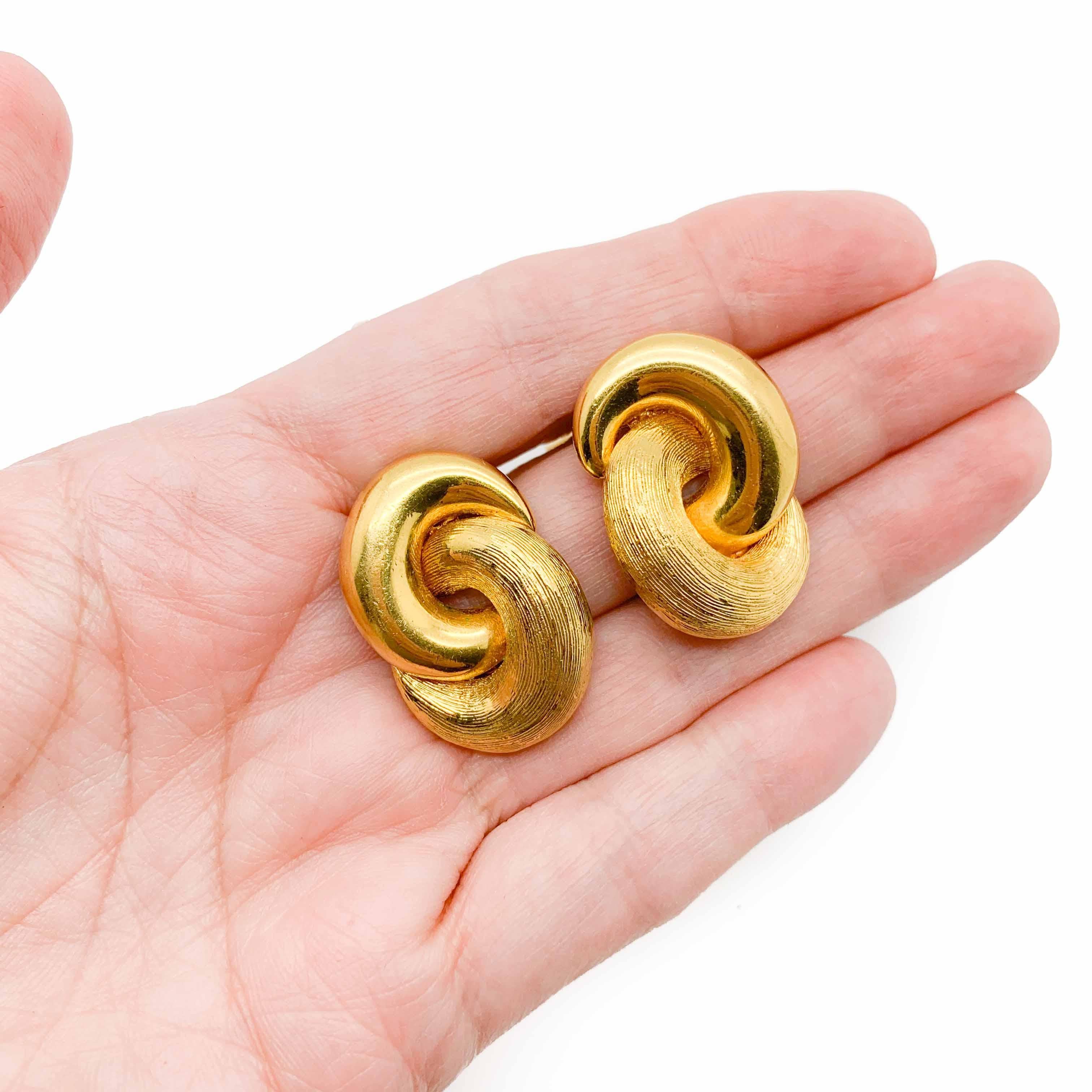 An exceptionally fabulous and timeless pair of vintage Dior Love Knot earrings. Featuring entwined gold loops depicting a love knot.  Crafted in high quality gold plated metal in a textured and a high polish finish for a perfect contrast and just