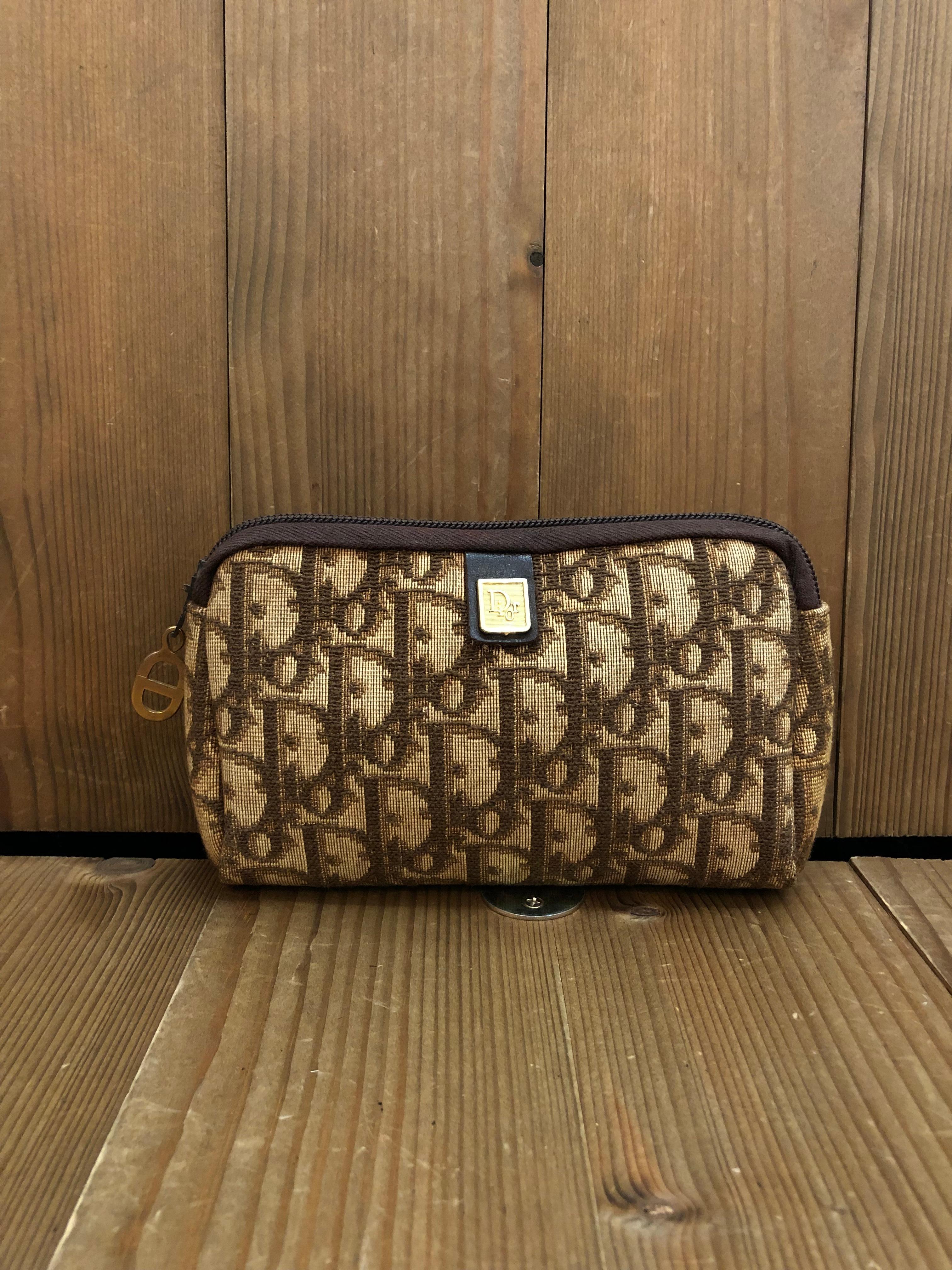 This Vintage CHRISTIAN DIOR mini vanity pouch is crafted of Dior signature Trotter jacquard in brown featuring gold toned hardware. Top zipper closure opens to a coated interior in brown. Made in France. Measures approximately 6.25 x 4 x 1.5 inches.