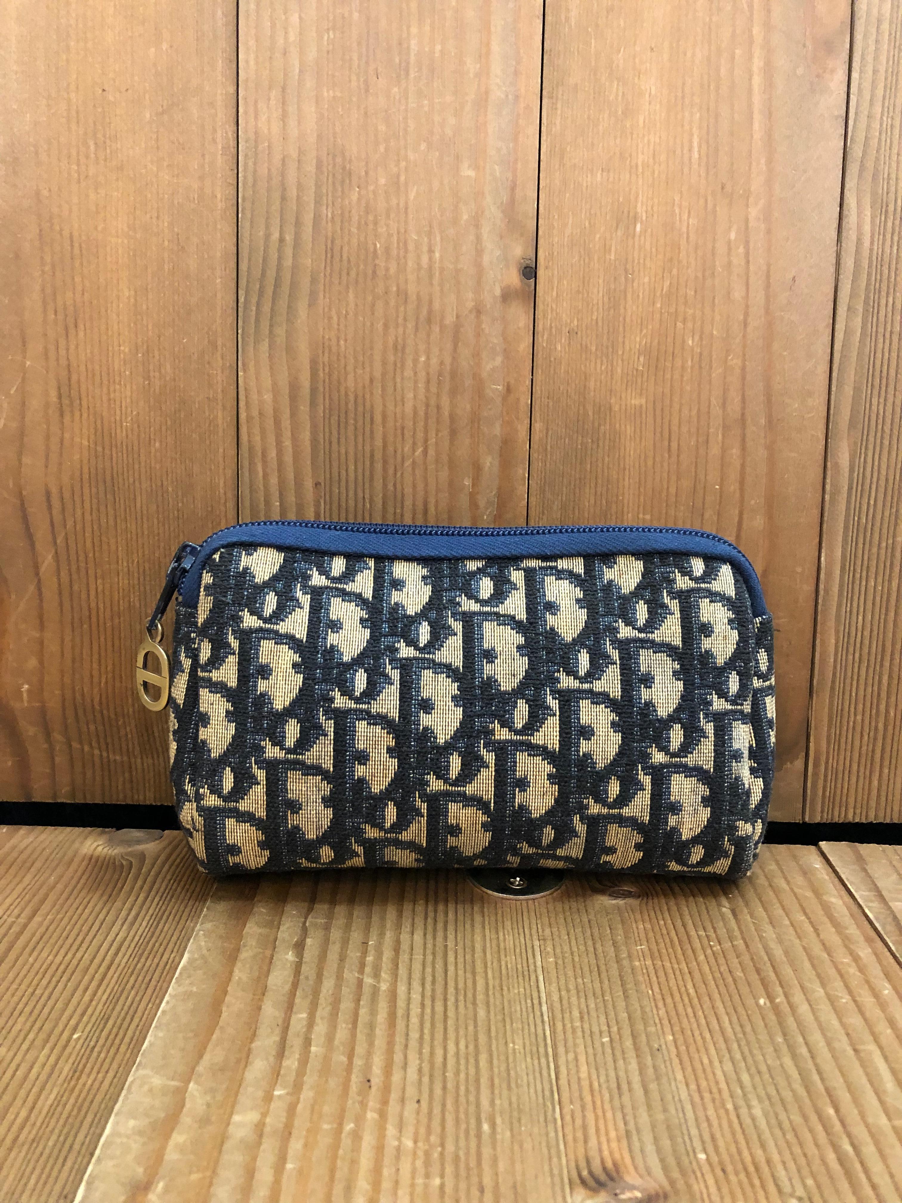 This Vintage CHRISTIAN DIOR mini vanity pouch is crafted of Dior signature Trotter jacquard in navy. Top zipper closure opens to a coated interior in navy. Made in France. Measures approximately 6 x 4 x 1.5 inches. 

Condition - Good vintage