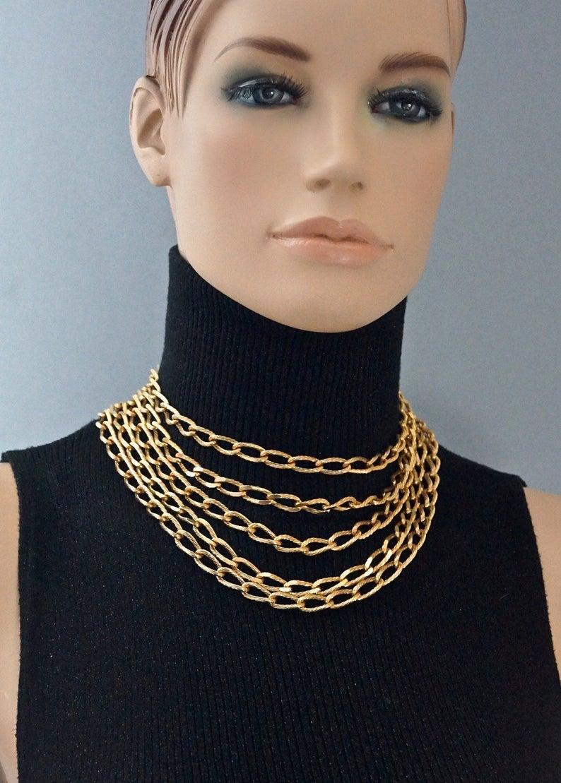 Vintage CHRISTIAN DIOR Multi Strand Chain Necklace

Measurements:
Chain drop at the centre: 3.93 inches (10 cm)
Wearable Length: 15.15 inches (38.5 cm)

Features:
- 100% Authentic CHRISTIAN DIOR.
- 5 layers/ strands of textured chain.
- Signed CHR