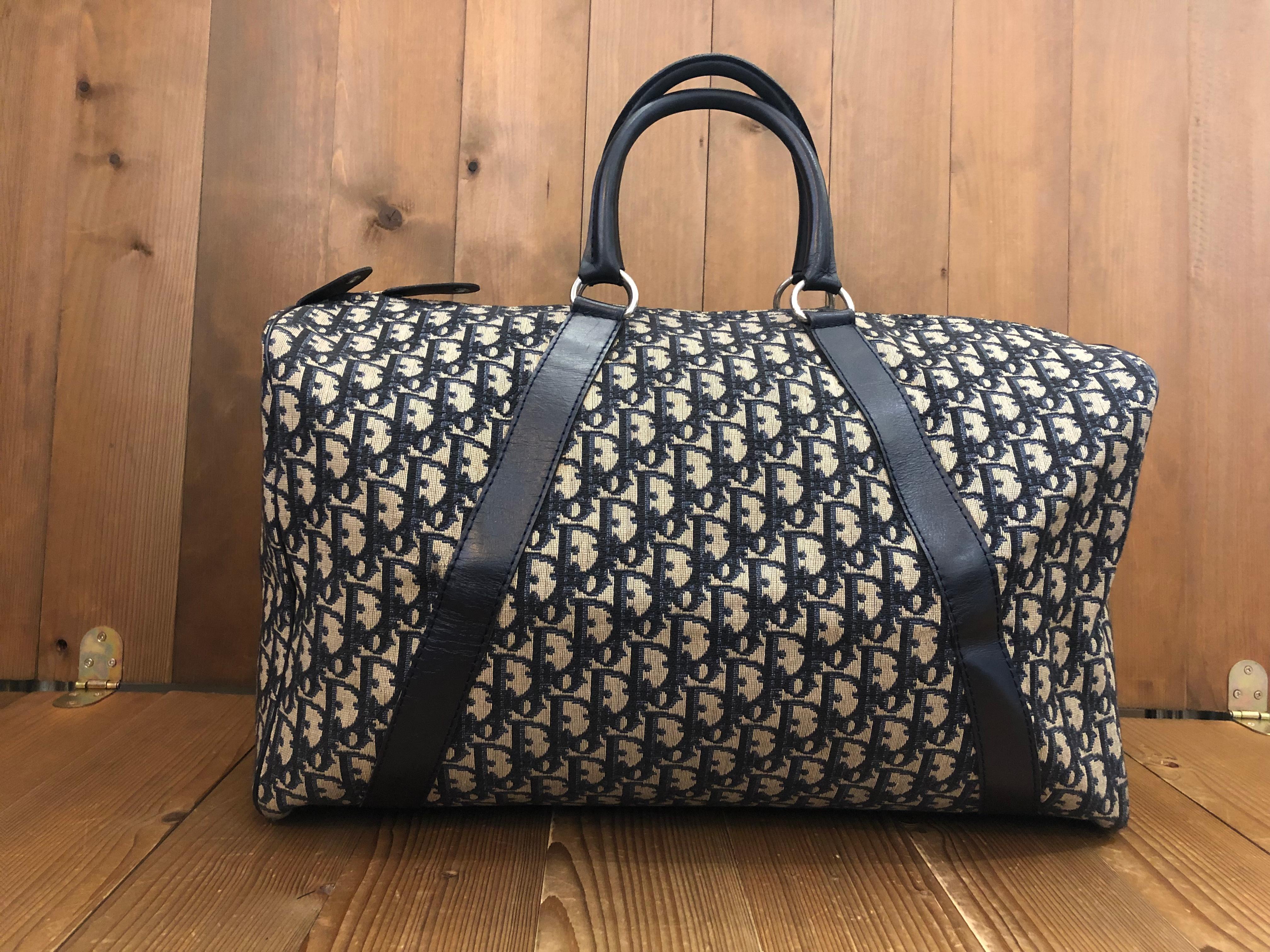 1970s CHRISTIAN DIOR boston duffle bag in navy trotter jacquard and leather trimmings featuring an navy all-leather interior and an interior zip pocket. This is an ideal duffle for a weekend getaway. Made in France. Measures approximately 18 x 11 x