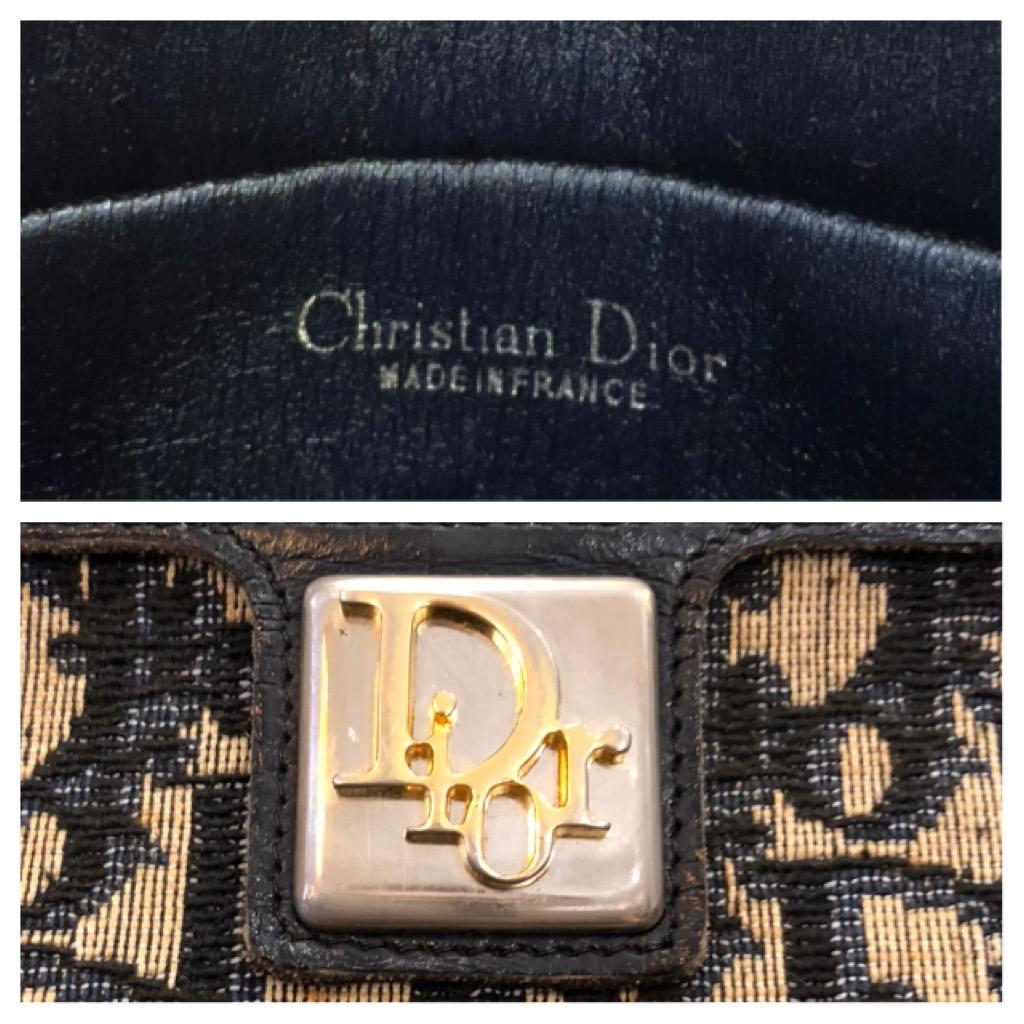 This vintage CHRISTIAN DIOR clutch bag is crafted of Dior signature trotter jacquard in navy trimmed with navy leather. Top spring closure opens to a navy leather interior. Third party clips and gold toned chain are added to carry the clutch as a