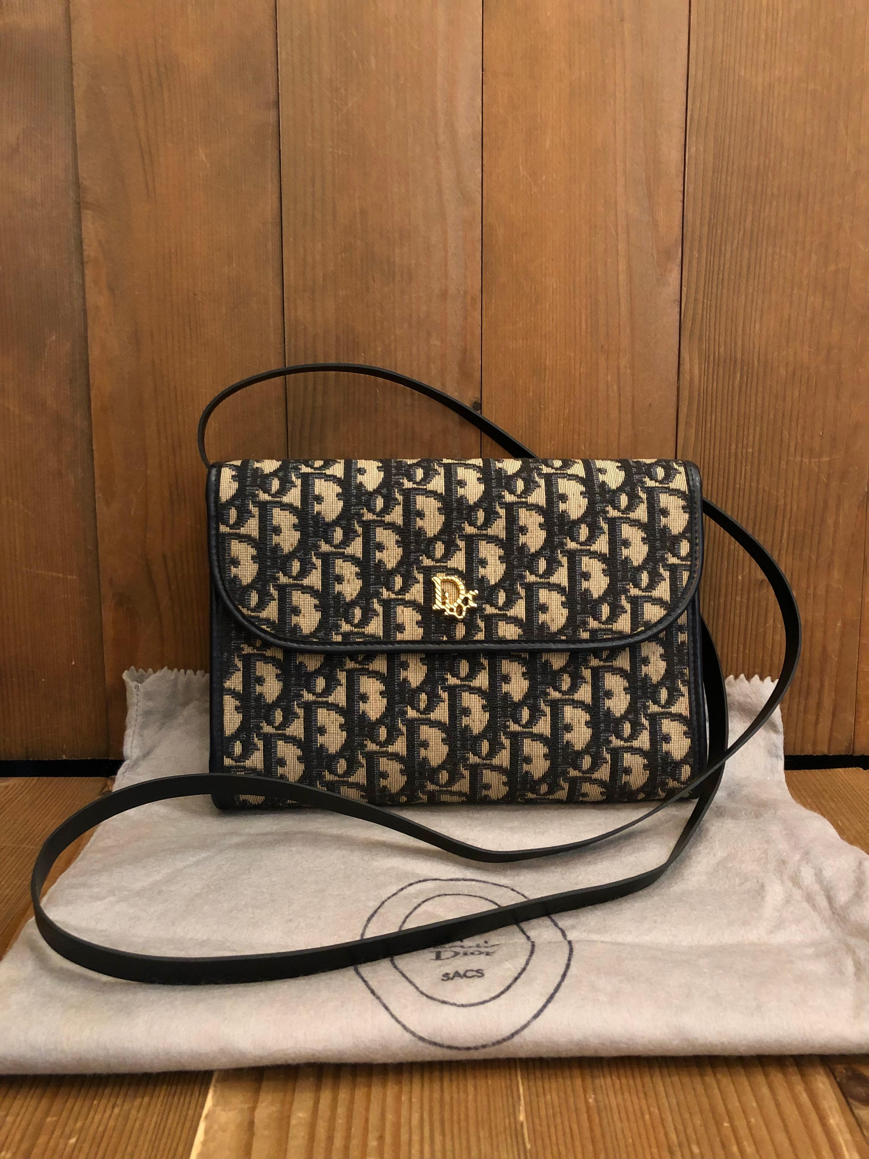 This beautiful vintage Christian Dior crossbody bag is crafted of Dior's signature trotter jacquard in navy trimmed with navy leather. Front flap closure with snap fastening opens to a navy leather interior featuring a zippered pocket. This vintage