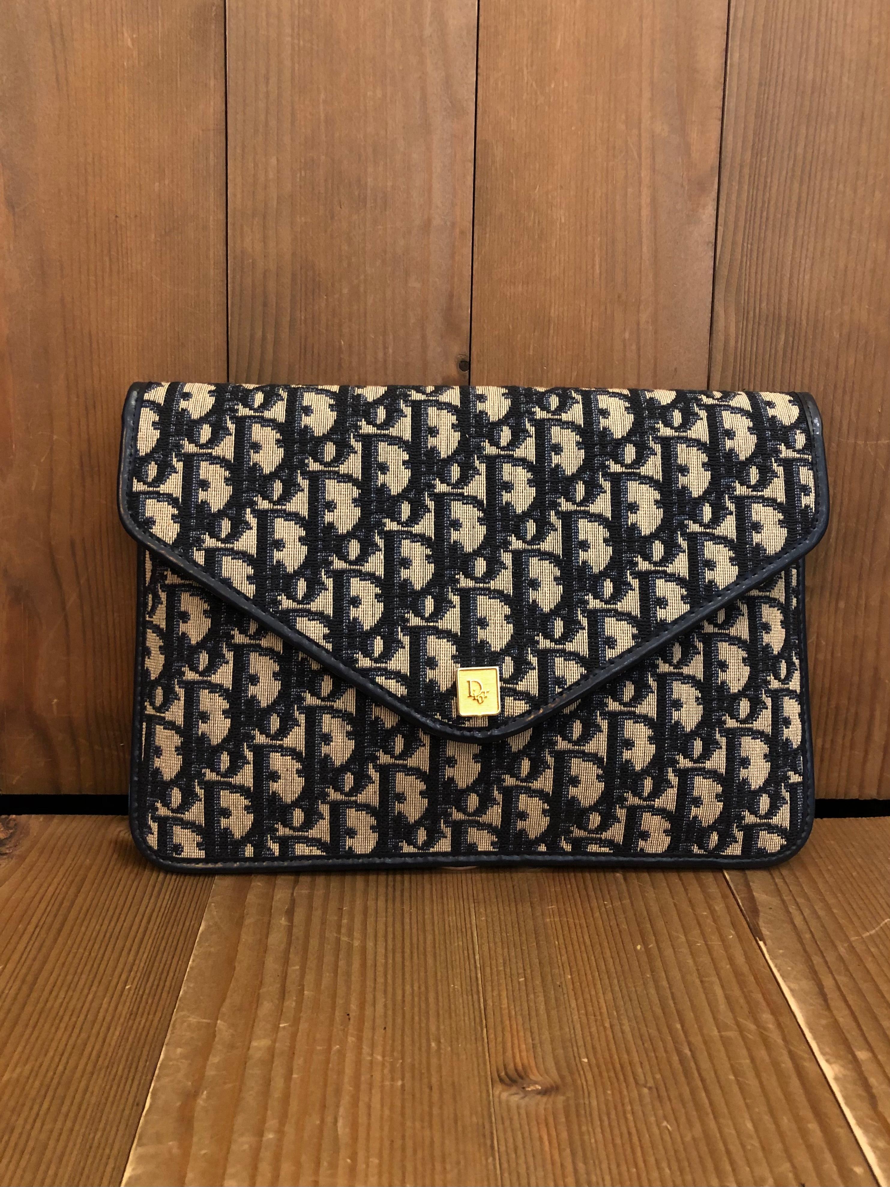 This vintage CHRISTIAN DIOR envelope clutch bag is crafted of Dior signature trotter jacquard in navy trimmed with navy leather. Front flap snap closure (replaced with magnetic snap) opens to a coated leather interior in navy. Made in France.