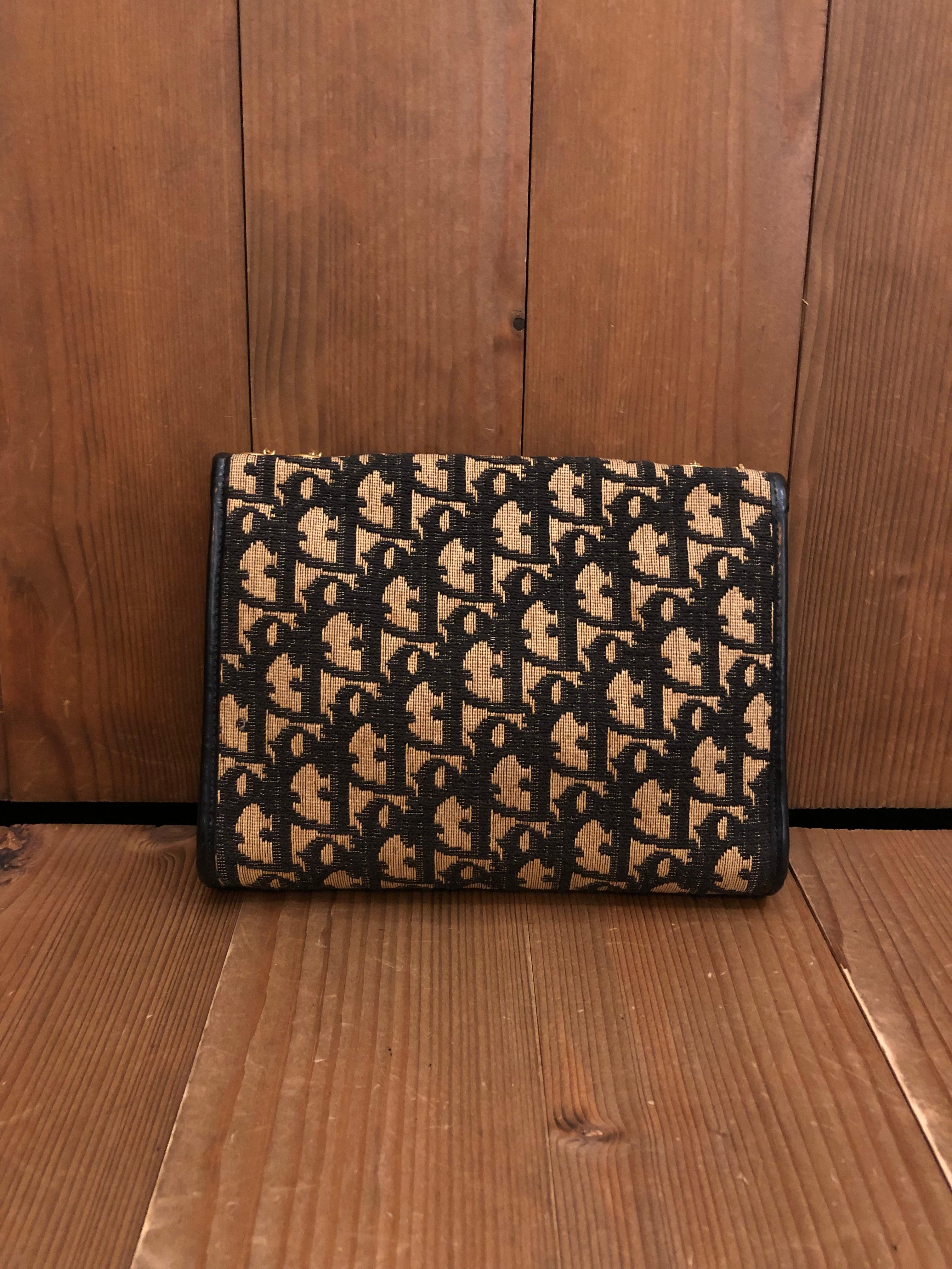 This is a rare vintage CHRISTIAN DIOR Saddle chain bag in Dior's signature trotter jacquard in navy. Front flap closure with replaced magnetic snap fastening opens to a navy leather interior. This vintage Dior features a gold toned chain that lets