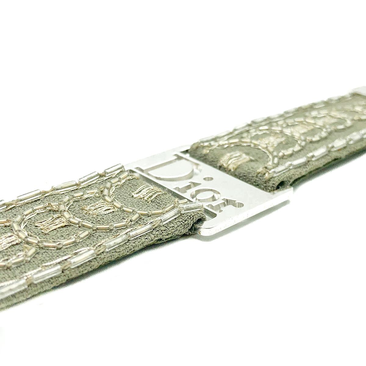 An ultra cool statement with this Vintage Dior Khaki Strap Bracelet.
Featuring an embroidered khaki grey fabric strap set with wonderfully high quality rhodium plated hardware. Rhodium plated end and the large Dior logo plaque set the pulse racing.