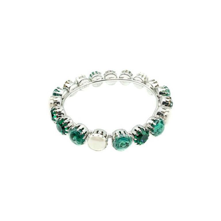 A most beautiful Vintage Christian Dior 1960s Bangle. Crafted in rhodium plated metal with the band lavishly embellished all around with emerald green glass and simulated glass pearls. Each one painstakingly claw set. The clever combination of the