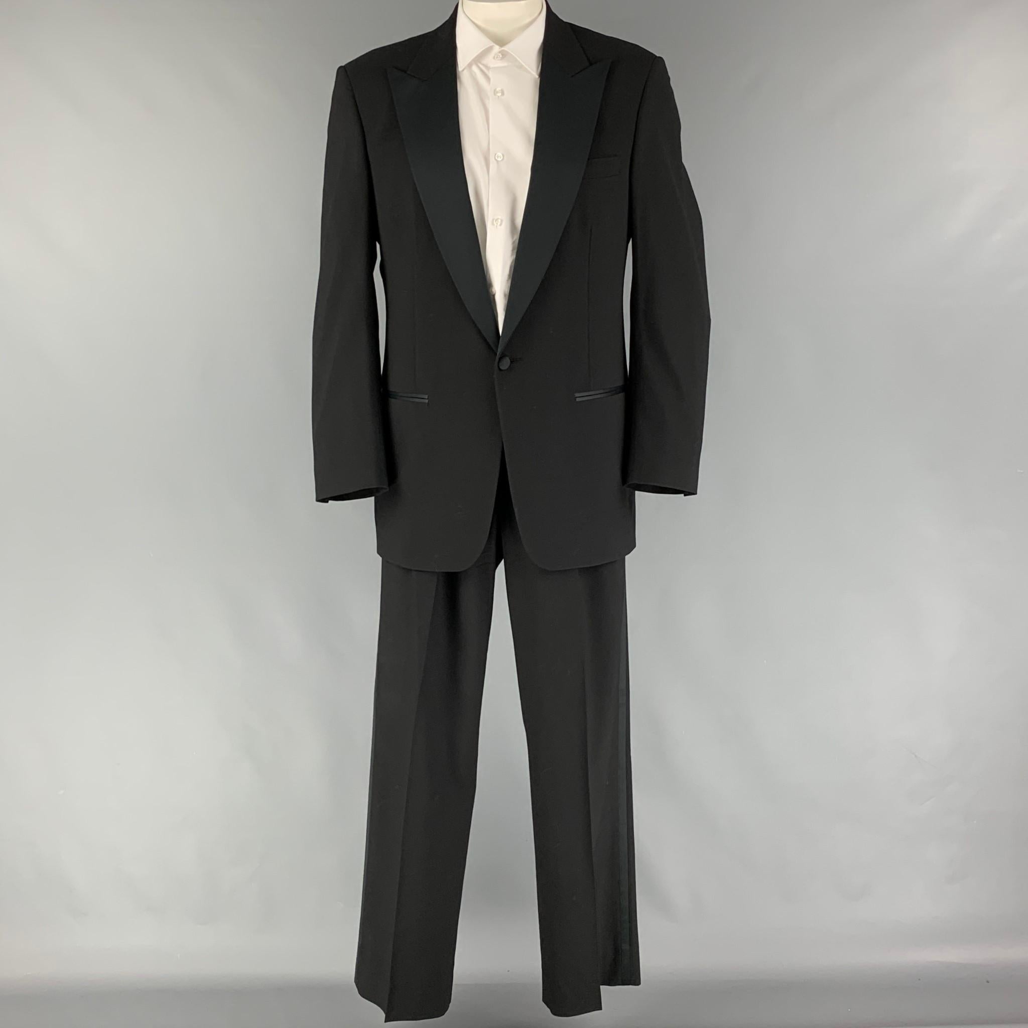 Vintage CHRISTIAN DIOR suit comes in a black virgin wool with a full liner and includes a single breasted, single button sport coat with a peak lapel and matching pleated front trousers.

Good Pre-Owned Condition.
Marked: 41