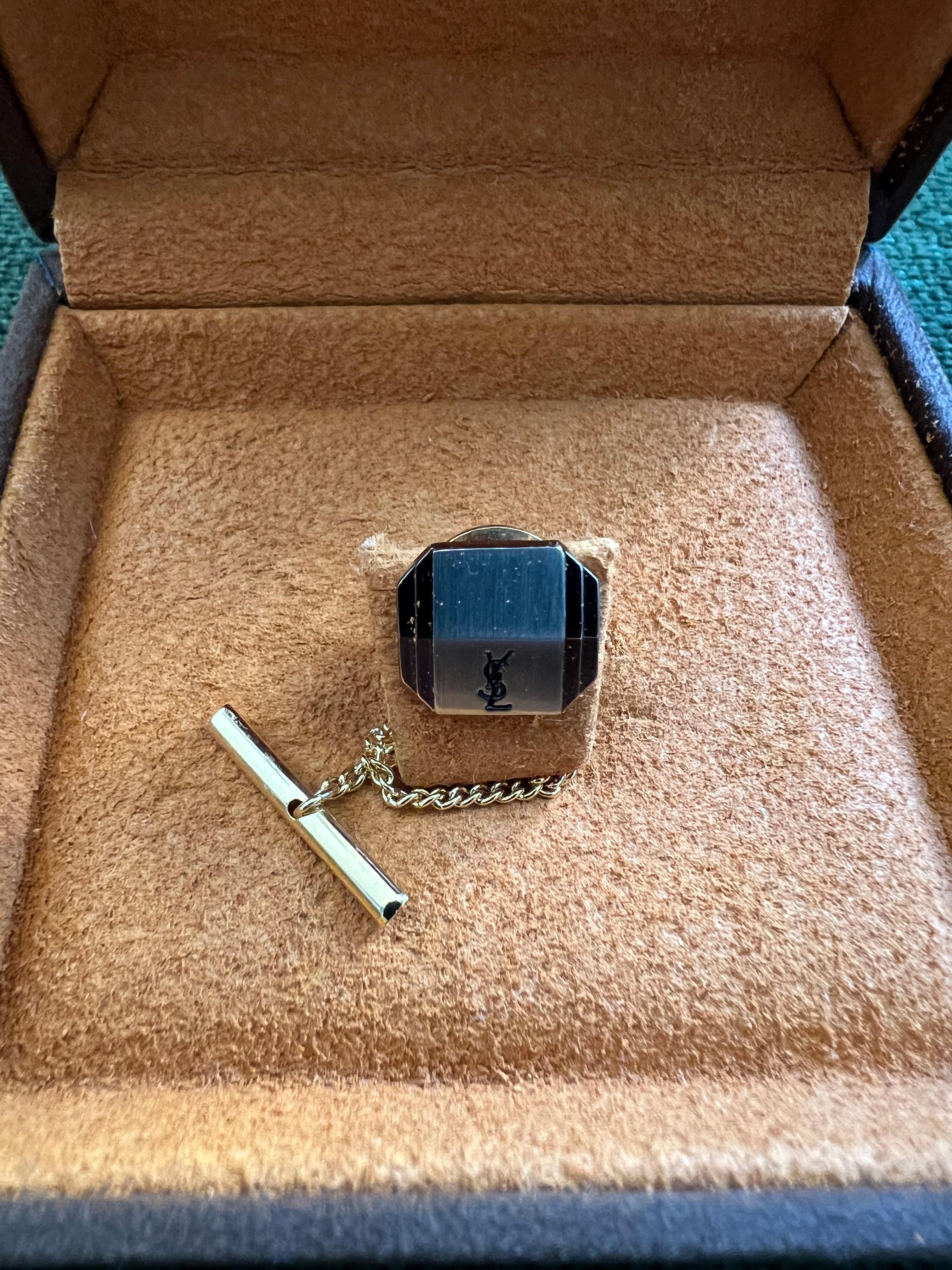 Vintage By Yves Saint Laurent YSL Logo Krawattennadel In Box Goldplatte und Edelstahl Krawattennadel mit einem Dior-Logo auf der Vorderseite, in Original YSL Schokolade Wildleder Fall. 
Circa 1990er Jahre 
In fantastischem Zustand
Retro, schick und