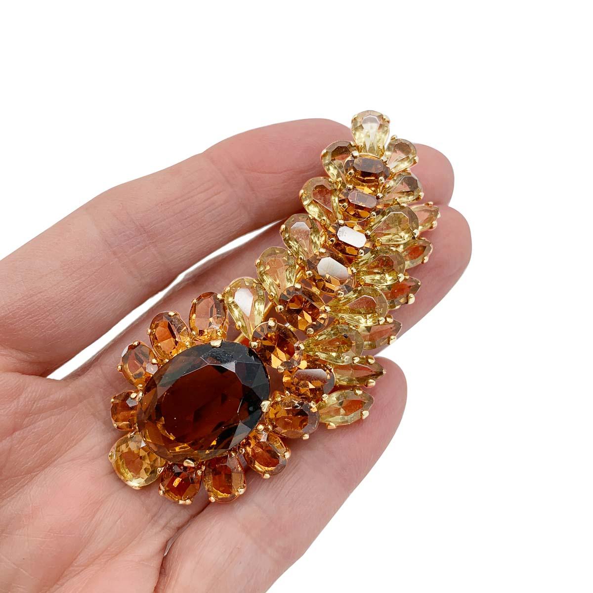 An exquisite vintage Christian Dior topaz brooch made in the year following Christian Dior's untimely passing, 1958 with Yves Saint Laurent at the helm of the House. Featuring a plume of citrine and topaz colour crystals in fancy cuts including