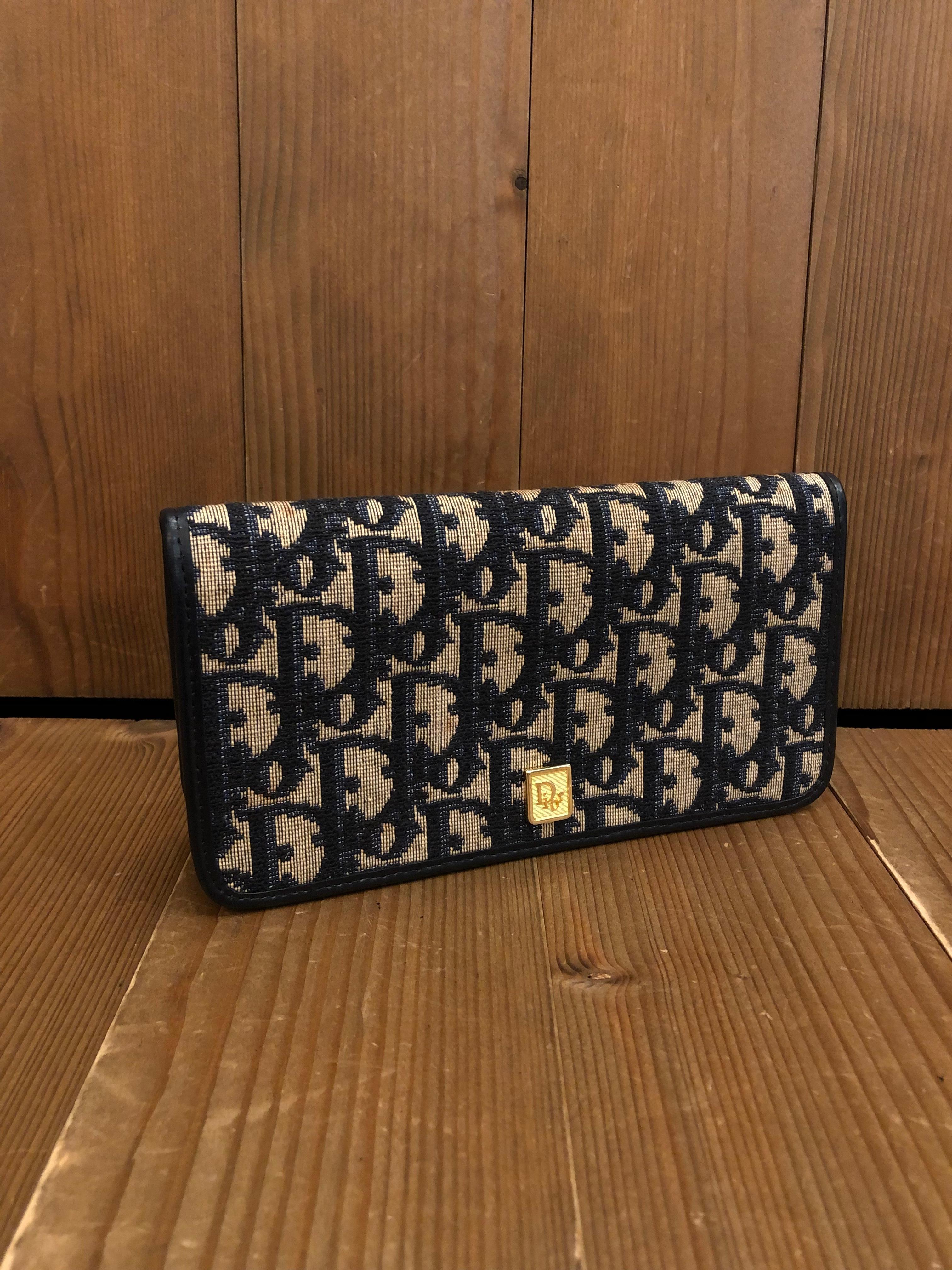 This vintage CHRISTIAN DIOR BI-fold long wallet is crafted of CD’s iconic Trotter jacquard in navy. Snap fastening opens to a smooth leather interior in navy featuring 2 bill and 1 coin pockets. With the gold toned chain and wallet-on-chain