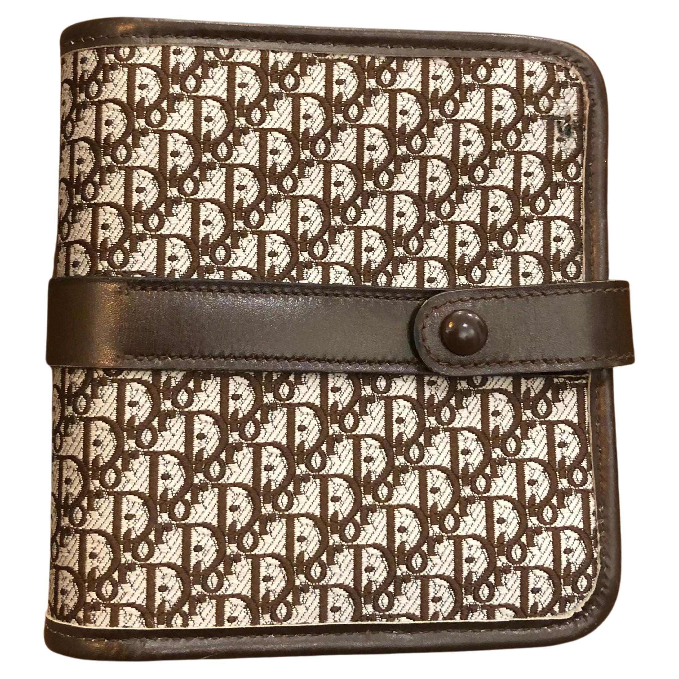 This vintage CHRISTIAN DIOR BI-fold short wallet is crafted of CD’s iconic micro Trotter jacquard in brown. Snap fastening opens to a smooth leather interior in brown featuring 1 card slot, 1 coin, 1 bill, and 2 inner pockets. Made in France.