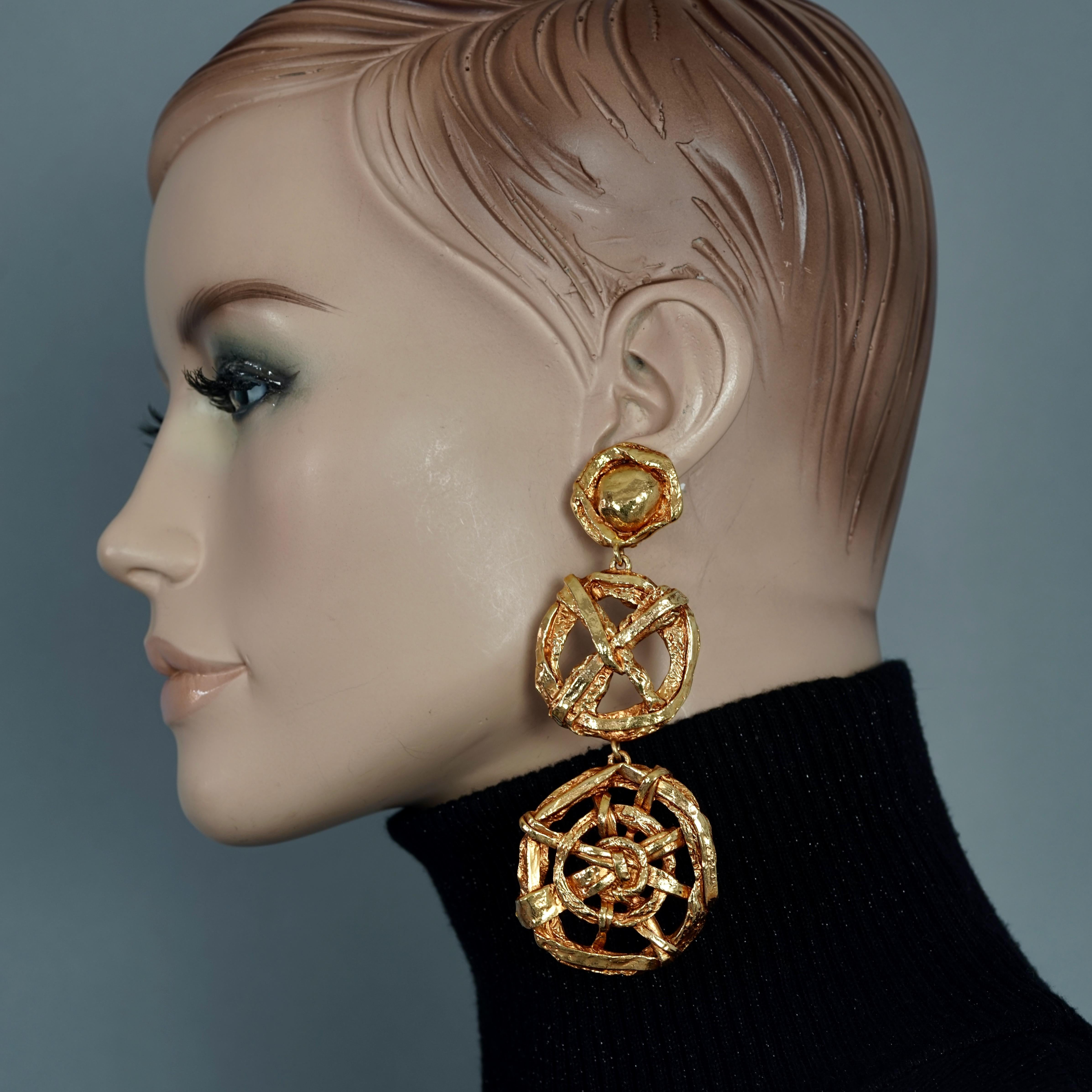 Vintage CHRISTIAN LACROIX 3 Tiered Nautical Wheel Dangling Earrings

Measurements:
Height: 2.12 inches (11 cm)
Width: 1.65 inches (4.5 cm)
Weight per Earring: 36 grams

Features:
- 100% Authentic CHRISTIAN LACROIX.
- 3 Tiered nautical wheel dangling