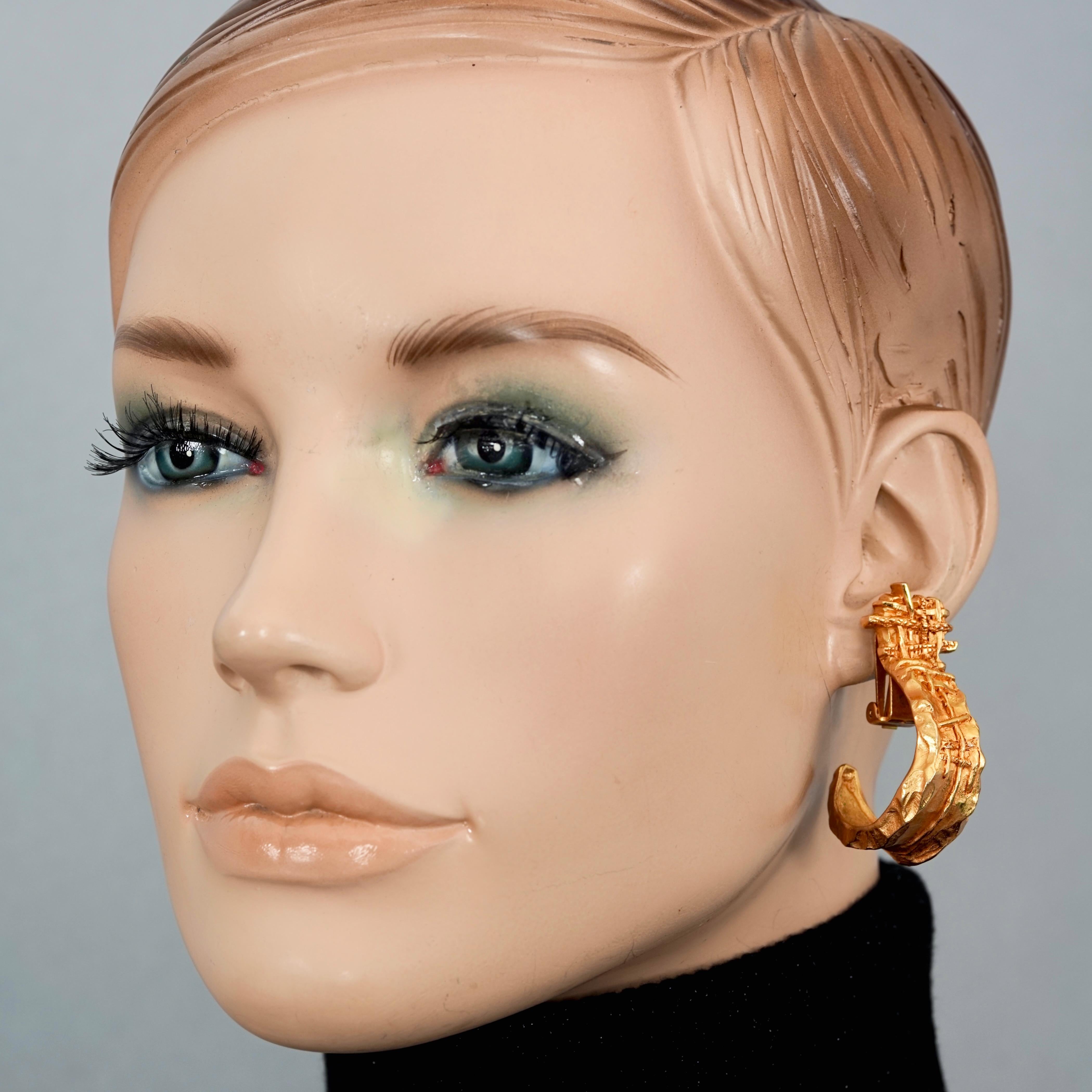 Vintage CHRISTIAN LACROIX Abstract Demi Creole Hoop Earrings

Measurements:
Height: 1.89 inches (4.8 inches)
Width: 0.63 inch (1.6 inches)
Weight per Earring: 19 grams

Features:
- 100% Authentic CHRISTIAN LACROIX.
- Hammered textured demi creole