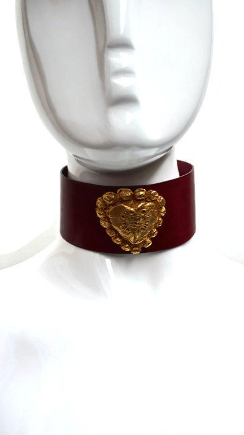 Vintage CHRISTIAN LACROIX by Ugo Correani Gilt Heart Red Leather Choker Necklace

Measurements:
Heart: 5 cm X 5 cm
Leather Band: 37 cm X 5 cm

Features:
- 100% Authentic CHRISTIAN LACROIX by Ugo Correani.
- Gilt metal textured heart center piece in