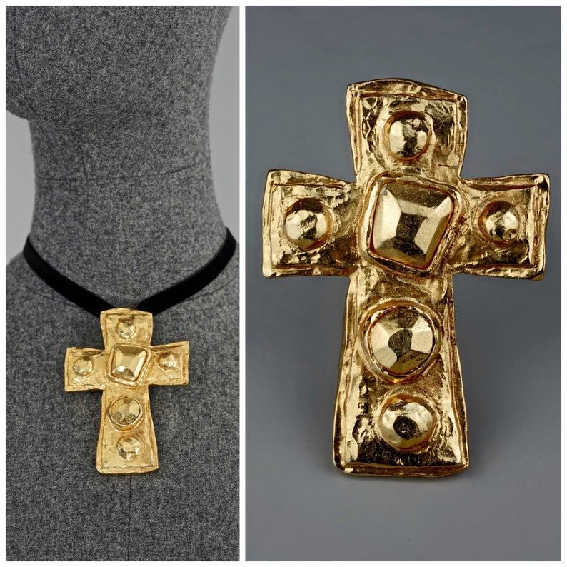 Vintage CHRISTIAN LACROIX Gilt Hammered Cross Pendant Brooch

Measurements:
Height : 3.42 inches (8.7 cm)
Width: 2.48 inches (6.3cm)

Features:
- 100% Authentic CHRISTIAN LACROIX.
- Hammered cross in gold tone.
- Accentuated with embossed geometric