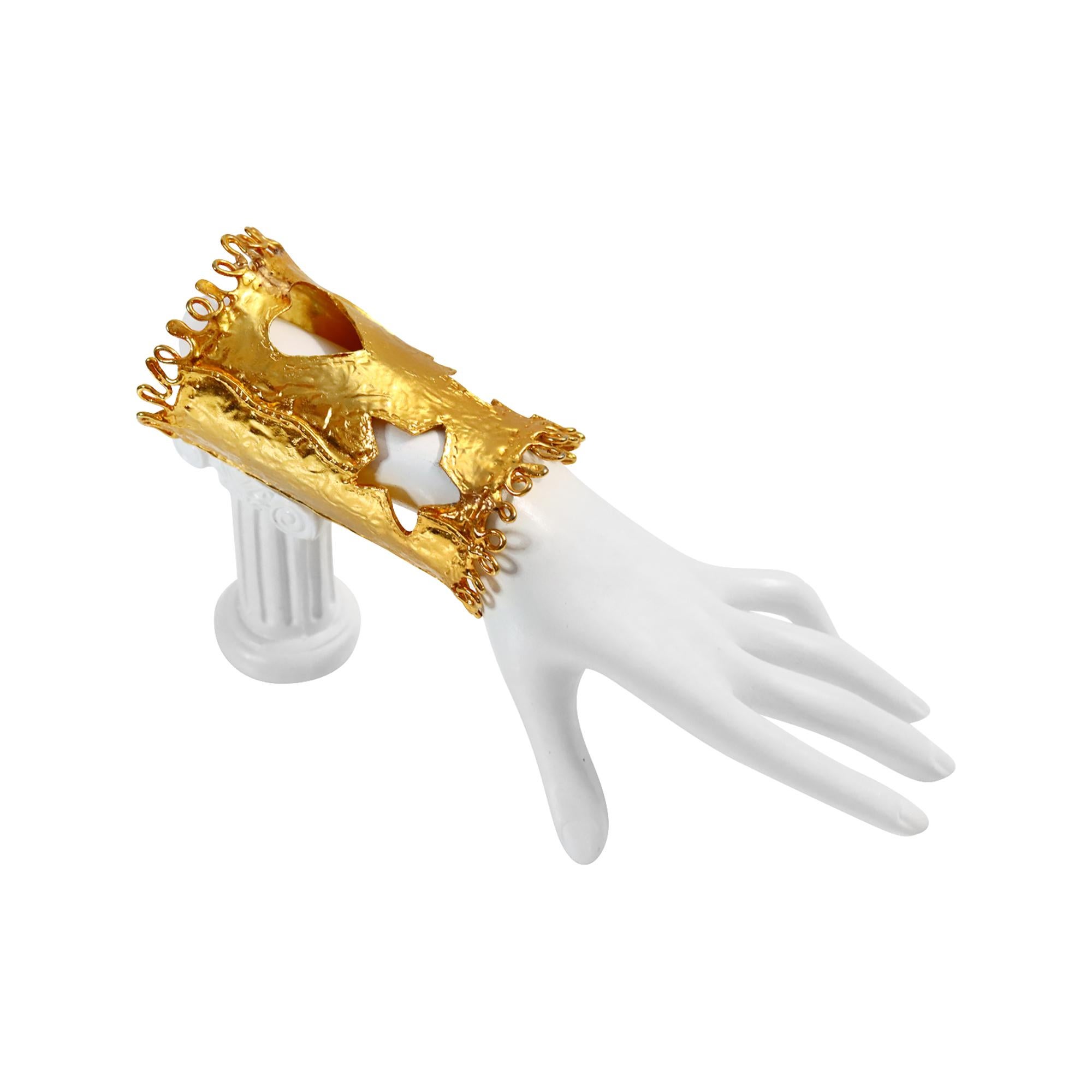 Vintage Christian Lacroix Paris Gold Iconic Ausschnitt Manschette CIRCA 1990er Jahre.  Die Manschette weist einen Ausschnitt mit Stern, Kreuz und Herz auf, mit gewirbelten Mustern auf der Ober- und Unterseite.  Sehr ikonische Manschette.  Das Metall