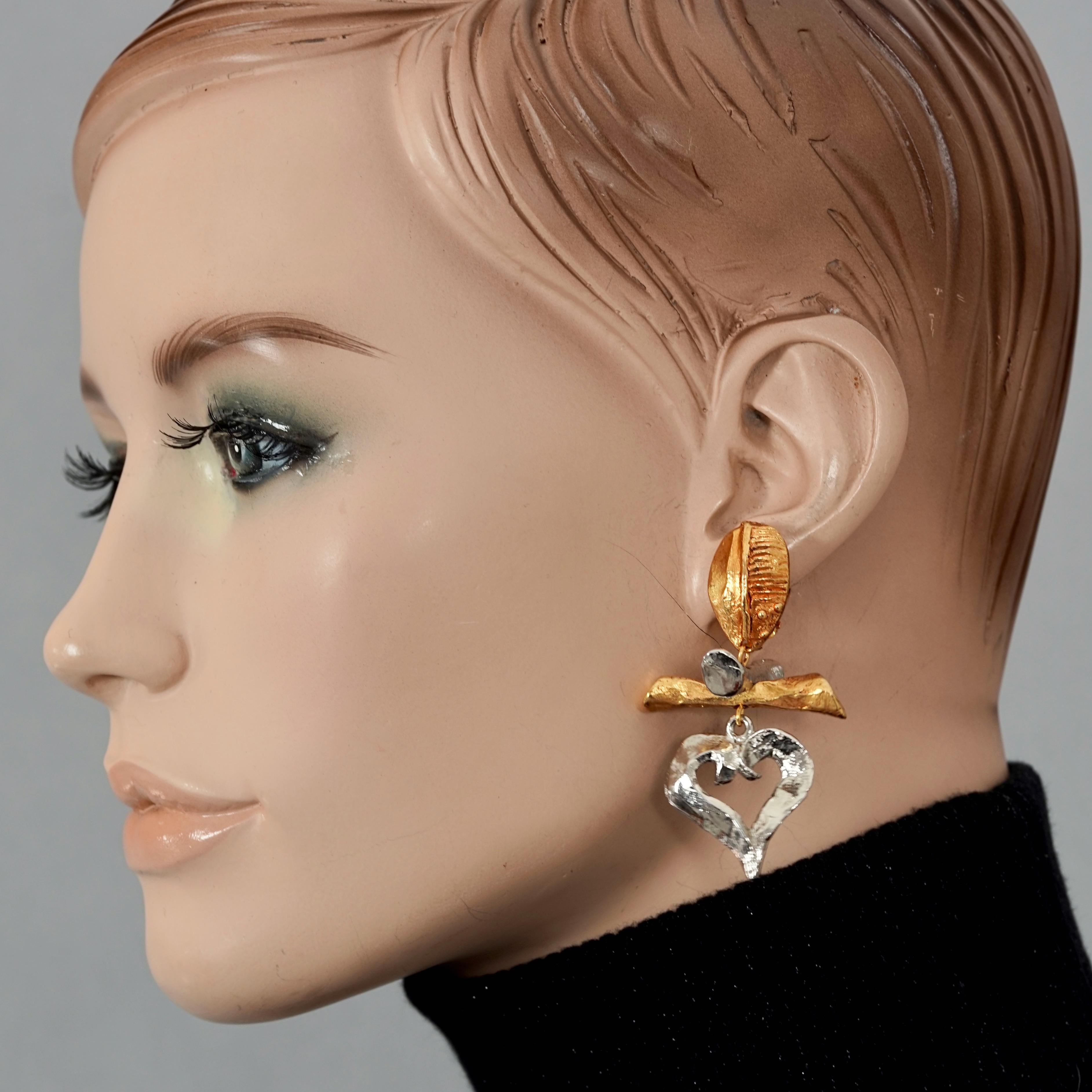 Vintage CHRISTIAN LACROIX Heart Charm Two Tone Dangling Earrings

Measurements:
Height: 2.36 inches (6 cm)
Width: 1.33 inches (3.4 cm)
Weight per Earring: 20 grams

Features:
- 100% Authentic CHRISTIAN LACROIX.
- Heart charm dangling earrings.
-