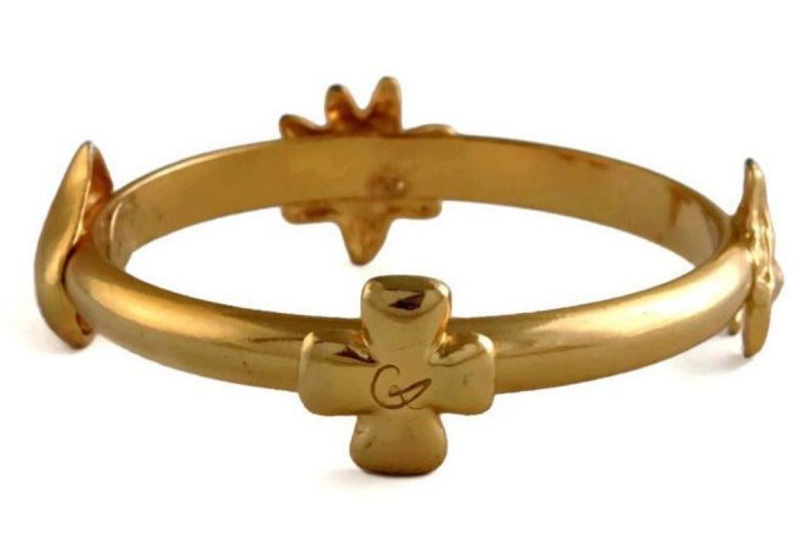 Vintage CHRISTIAN LACROIX Iconic Logo Symbol Bangle Bracelet

Measurements:
Height: 0.86 inch
Inside Diameter: 2.55 inches

Features:
- 100% Authentic CHRISTIAN LACROIX.
- Lacroix iconic symbols: Cross with CL logo, Star, Heart and Bull.
- Signed