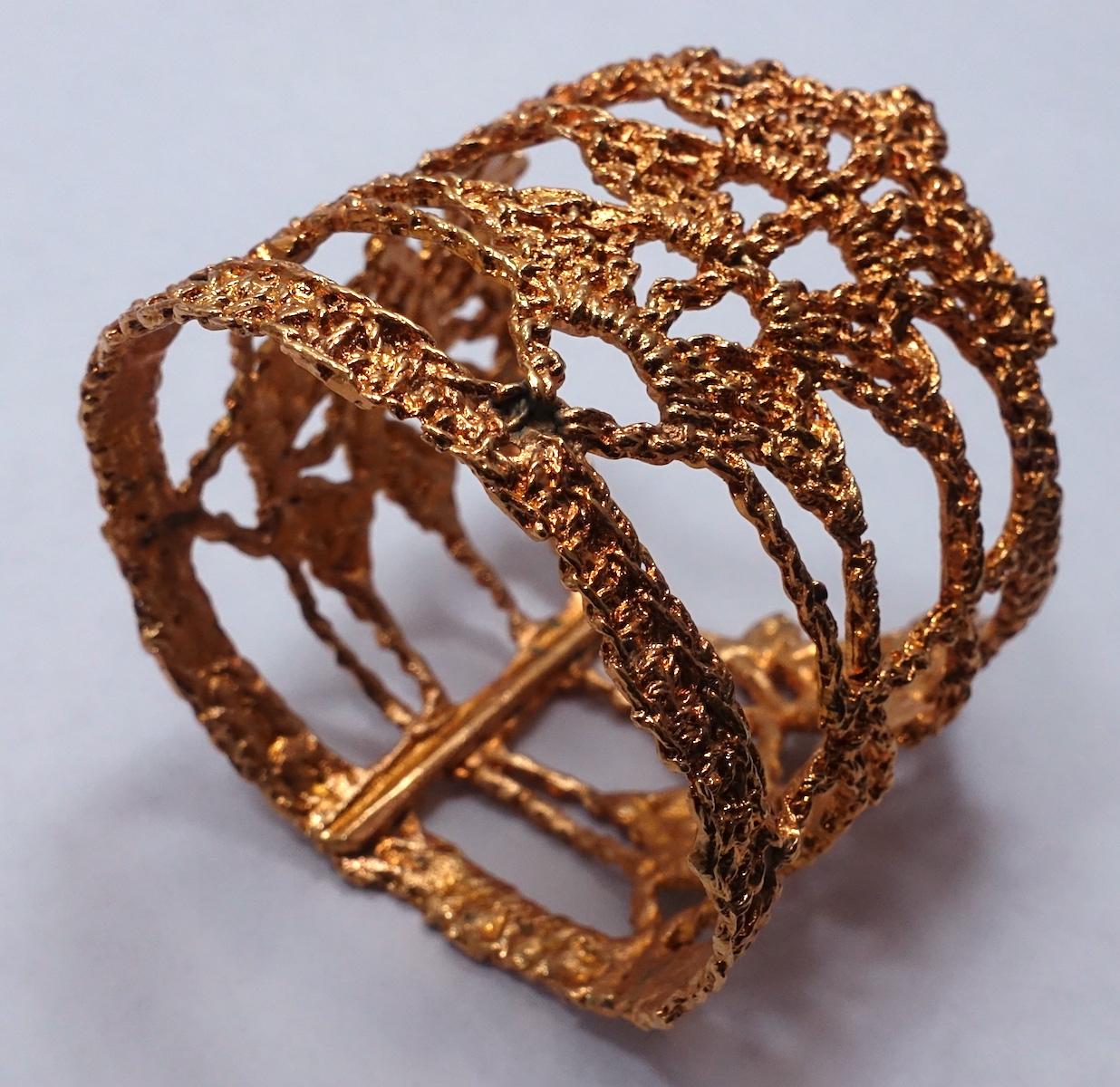 This vintage signed Christian Lacroix wide cuff bracelet has a heavily intricate openwork design in a gold tone setting.  This cuff measures 3” x 2-5/8” and will fit a size 7-1/2” wrist.  It is signed “Christian Lacroix Made in France” and is in