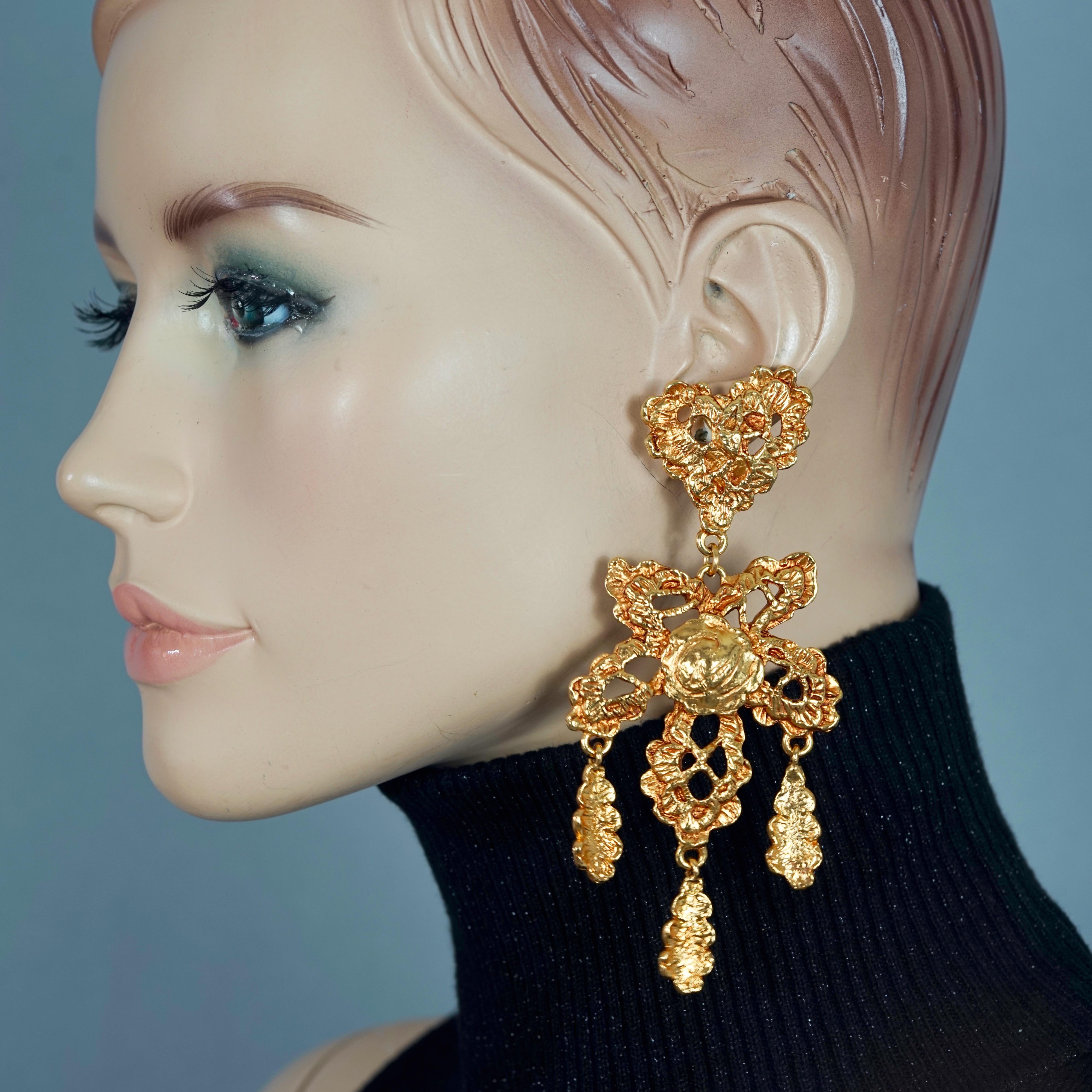 Vintage CHRISTIAN LACROIX Logo Lace Heart Flower Dangling Earrings

Measurements:
Height: 4.52 inches (11.5 cm)
Width: 2.04 inches (5.2 cm)
Weight per Earring: 33 grams

Features:
- 100% Authentic CHRISTIAN LACROIX.
- Long gilt lace heart and flower