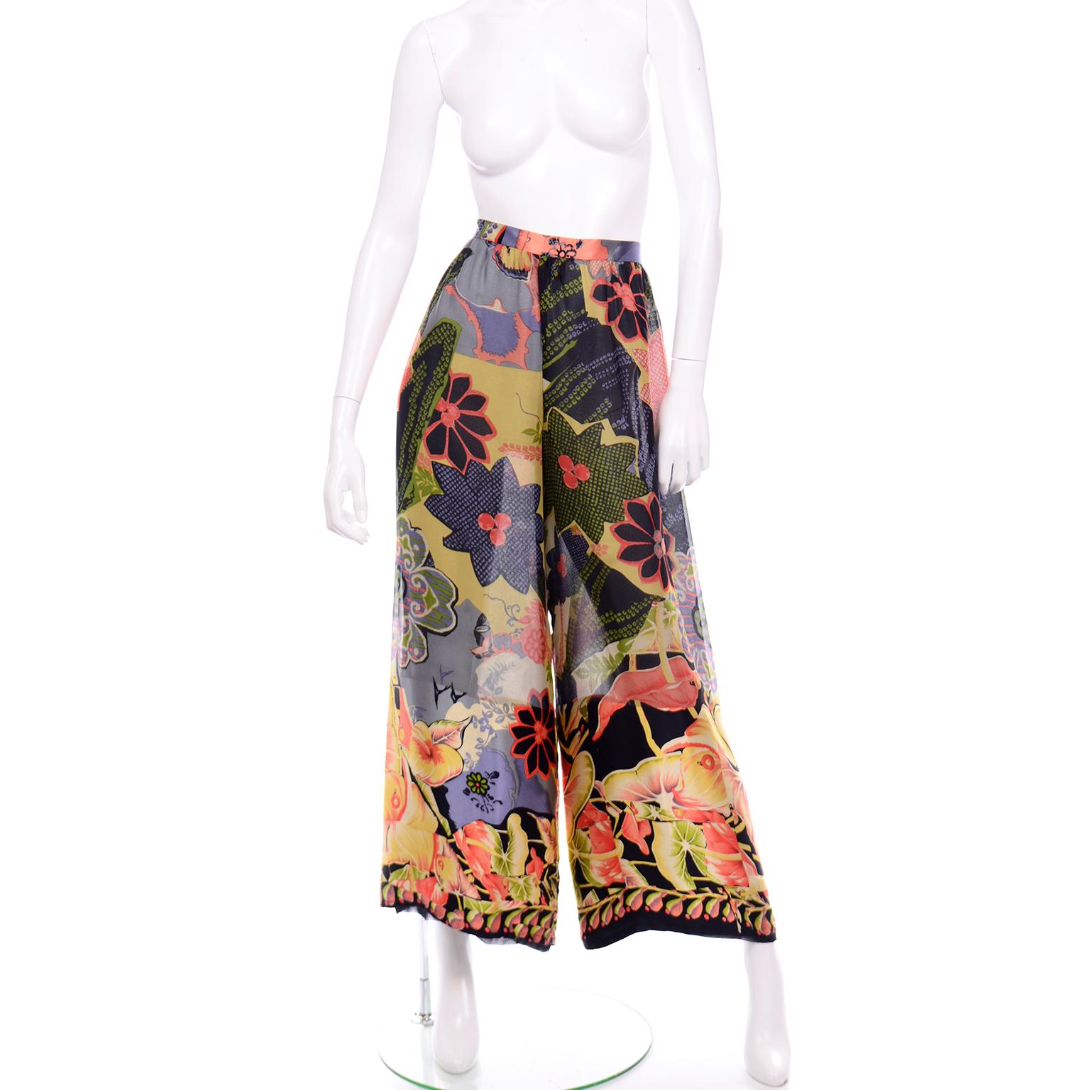 These fabulous vintage 1980's Christian Lacroix pants are in a beautiful floral abstract print silk chiffon. The bold tropical botanical print is in shades of green, purple, salmon, yellow and black. These high waisted, wide leg trousers would be