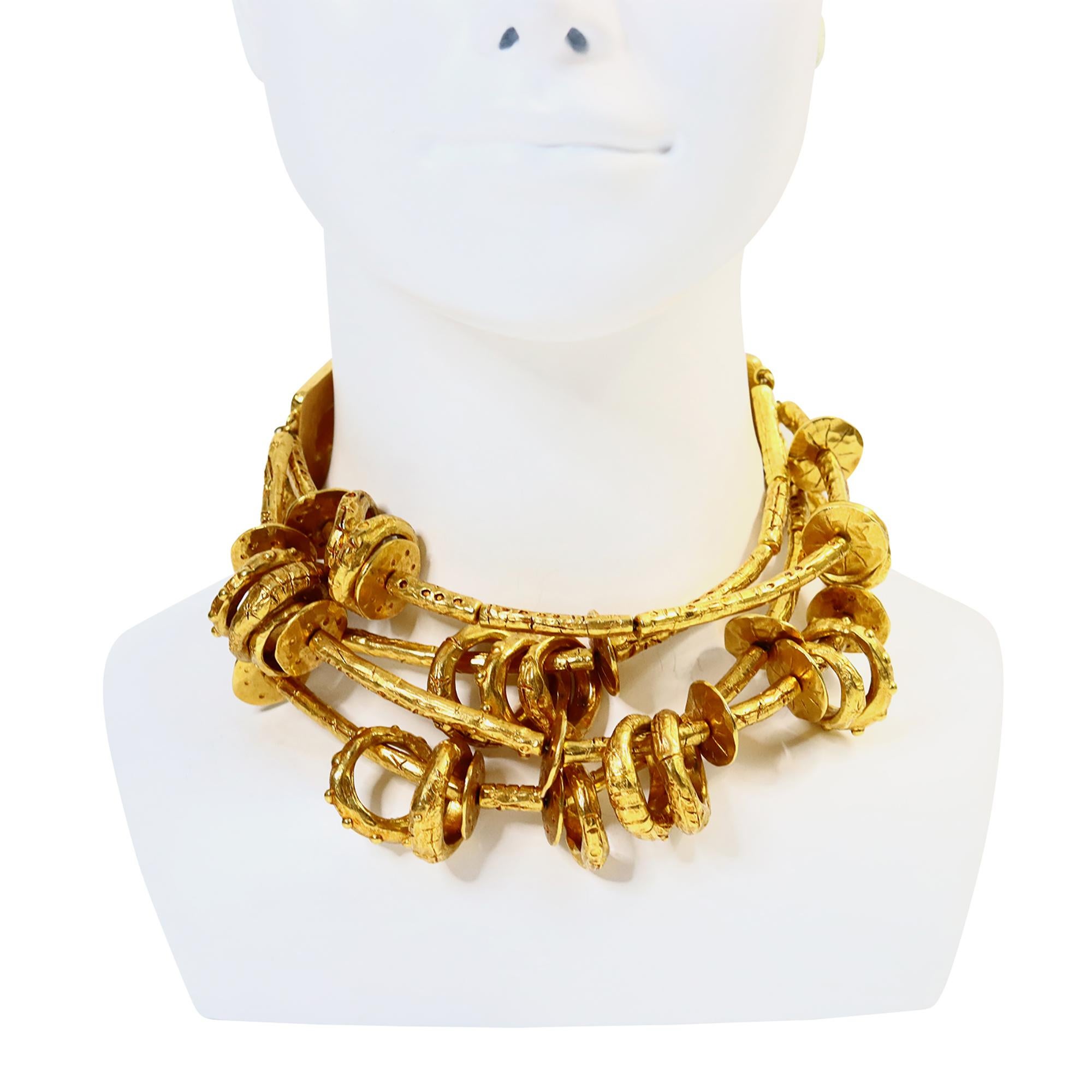 Il raro e massiccio girocollo di ispirazione etnica tribale a quattro fili in oro di CHRISTIAN Lacroix è caratterizzato da maglie e anelli. Entrambe le estremità sono realizzate con smalto rosso intenso tempestato di cabochon di resina arancione.