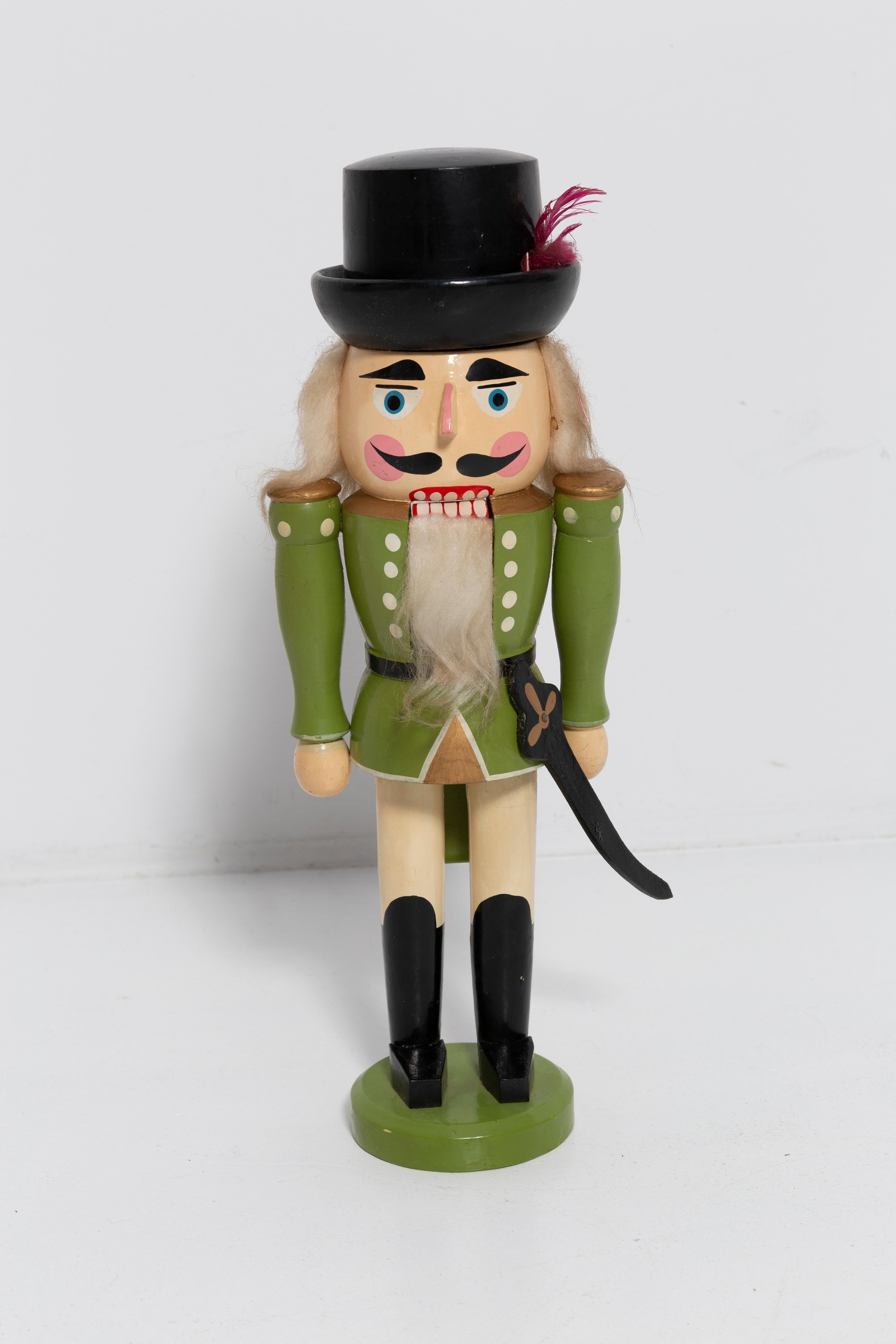 Big wooden nutcracker figure from the Erzgebirge. The region Erzgebirge formerly Eastern Germany is famous for this special kind of nutcrackers, where intricate carving has been their home. Completely hand-painted in bright colors and decorated with