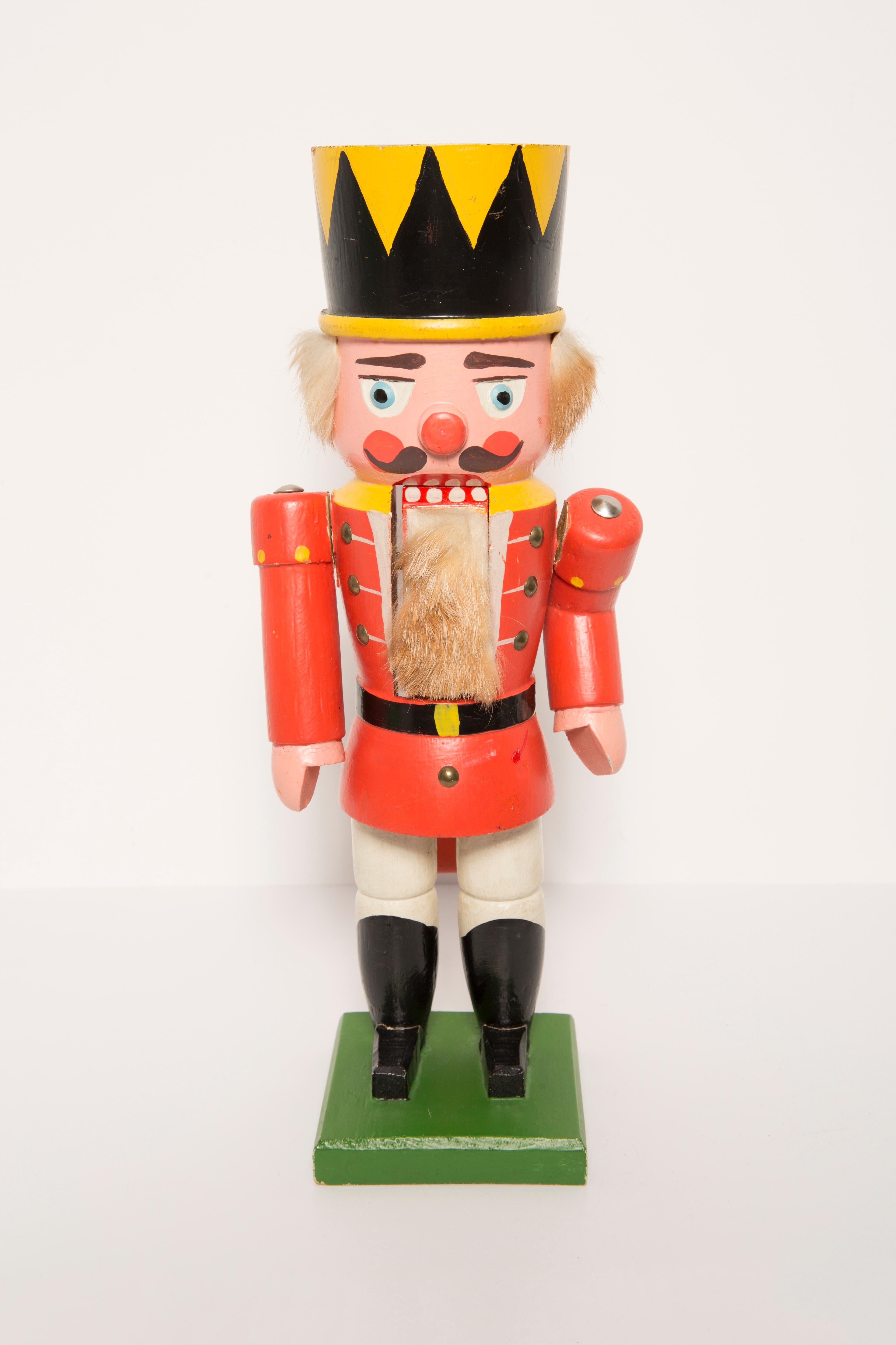 Big wooden nutcracker figure from the Erzgebirge. The region Erzgebirge formerly Eastern Germany is famous for this special kind of nutcrackers, where intricate carving has been their home. Completely hand-painted in bright colors and decorated with