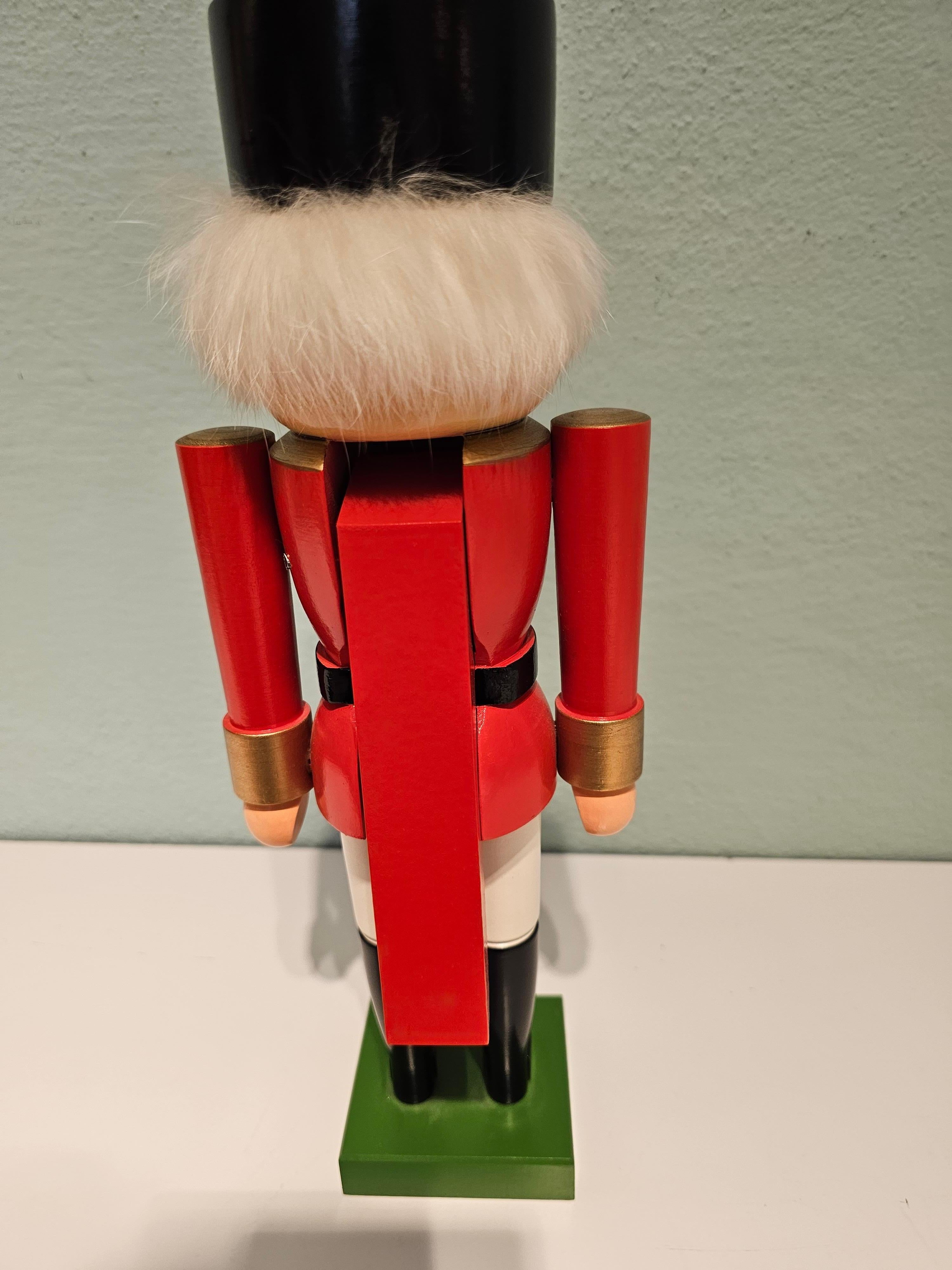 Vintage wooden nutcracker figure from the Erzgebirge. The region Erzgebirge formerly Eastern Germany is famous for this special kind of nutcrackers, where intricate carving has been their home. Completely hand-painted in red and white colors and